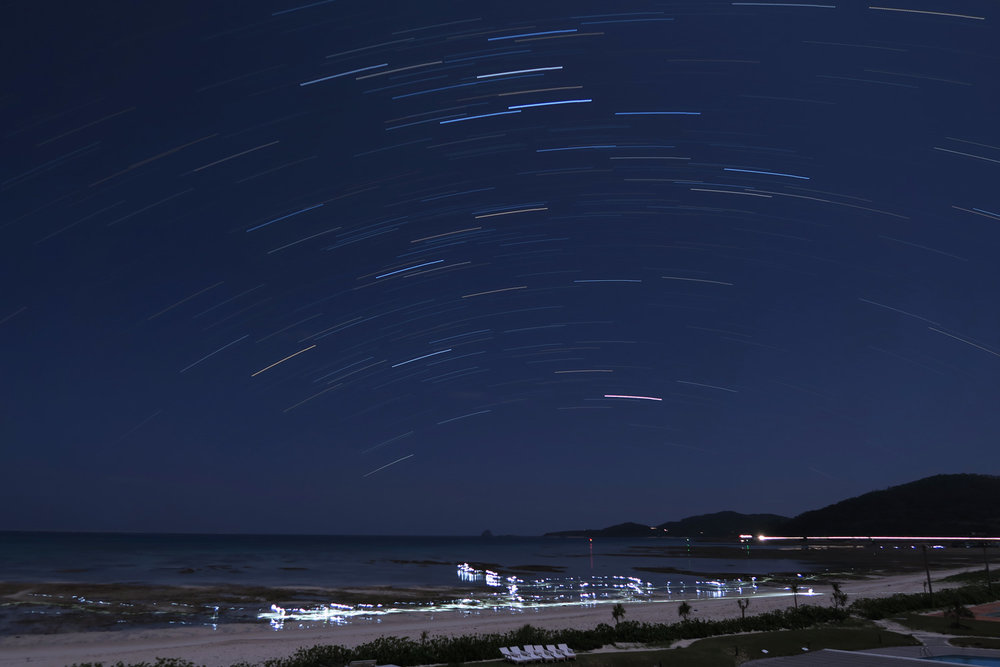 30 minute star trail exposure with people looking for crabs with flashlights at 2:00am.