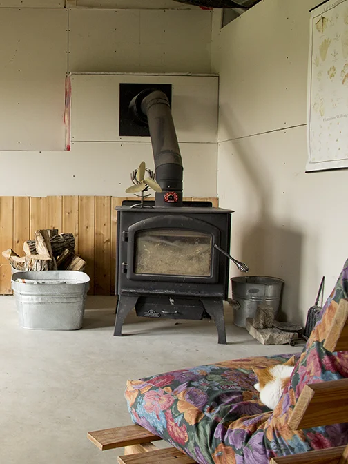 Wood stove in basement. The house is heated by a high-efficiency propane furnace and this high-efficiency stove.
