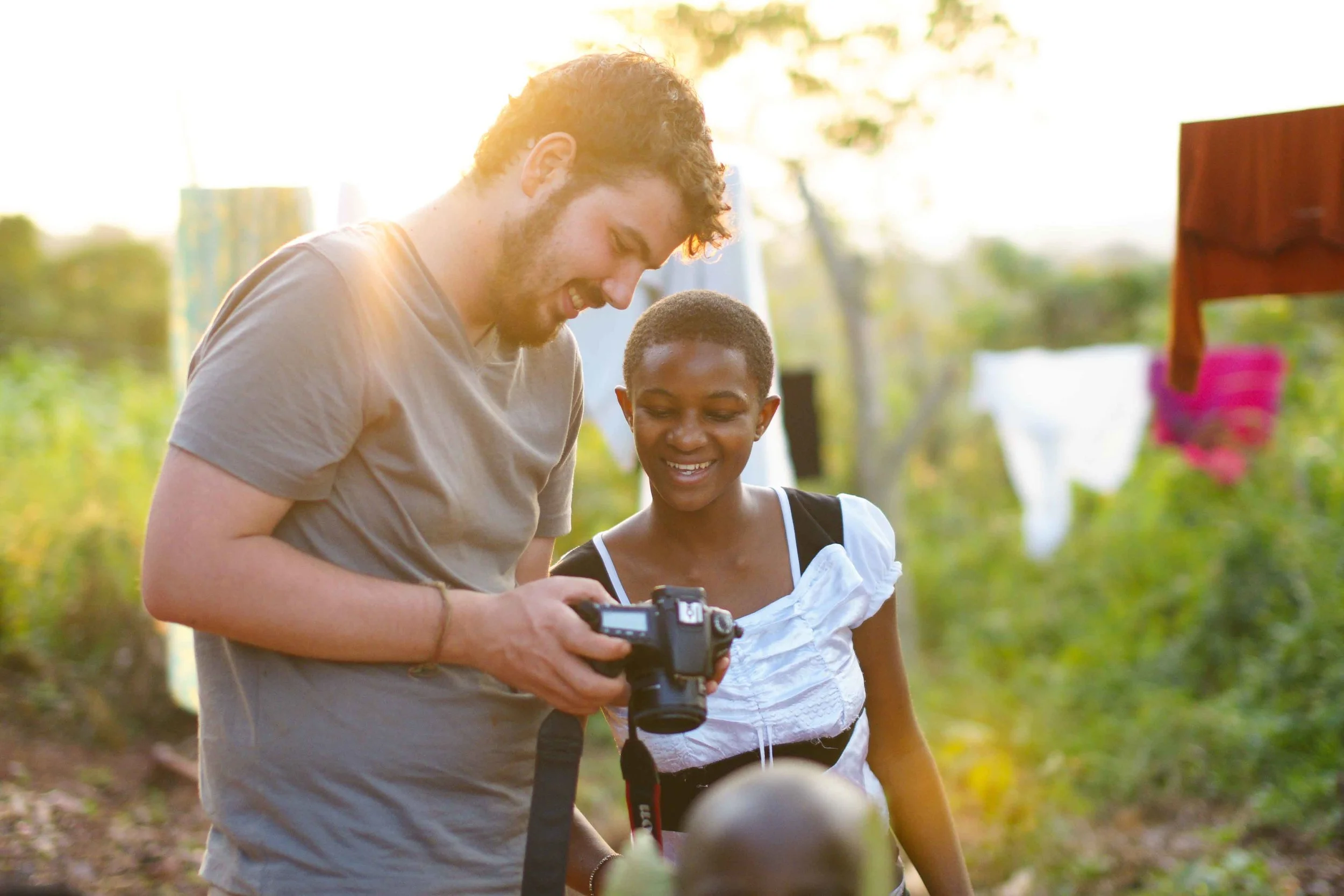 Fellow photographer Ryan Ihle shows a portrait to a child sponsored by GAAF. Uganda