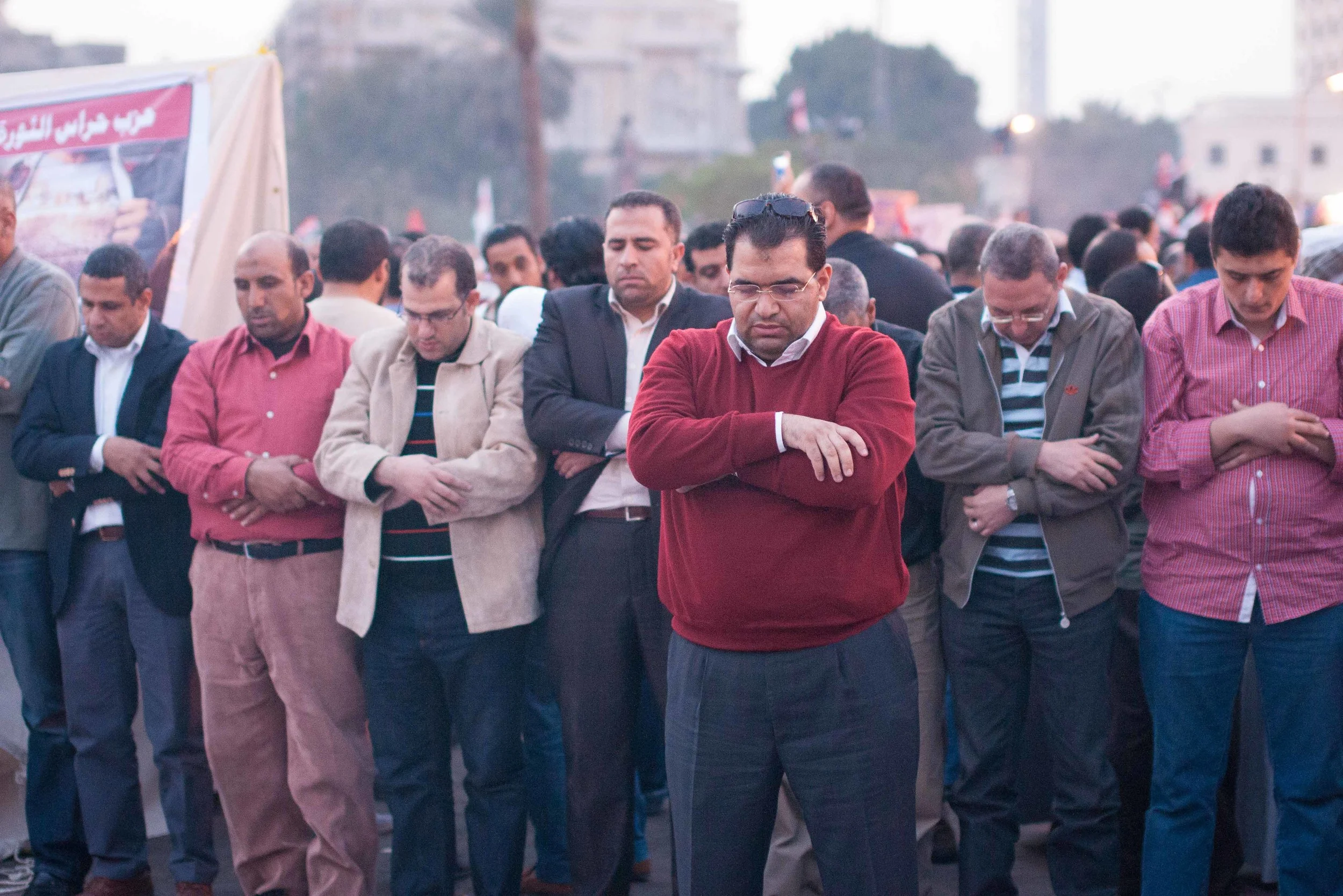 A man leads the prayer in Tahrir Square as the sun begins to set.