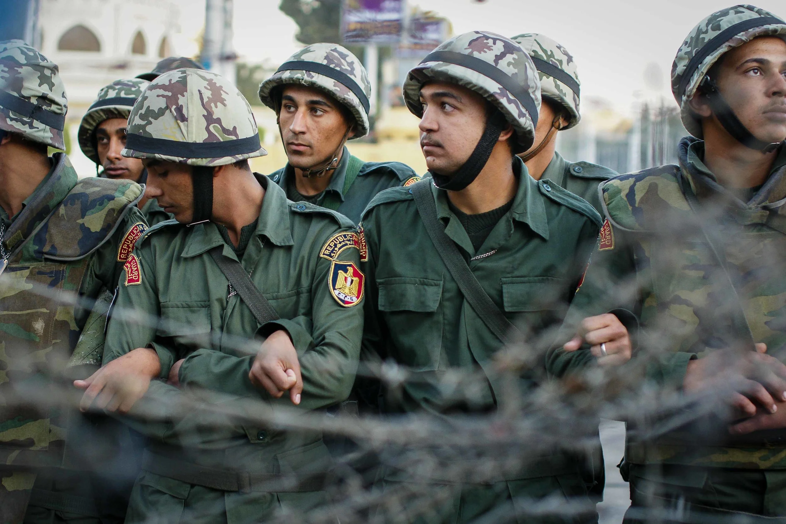 M embers of the military and Republican Guard link arms in anticipation of protestors crossing the barrier. It was later breached, and protestors flooded the street in front of the Palace. The Guard, surprisingly, showed them no resistance.