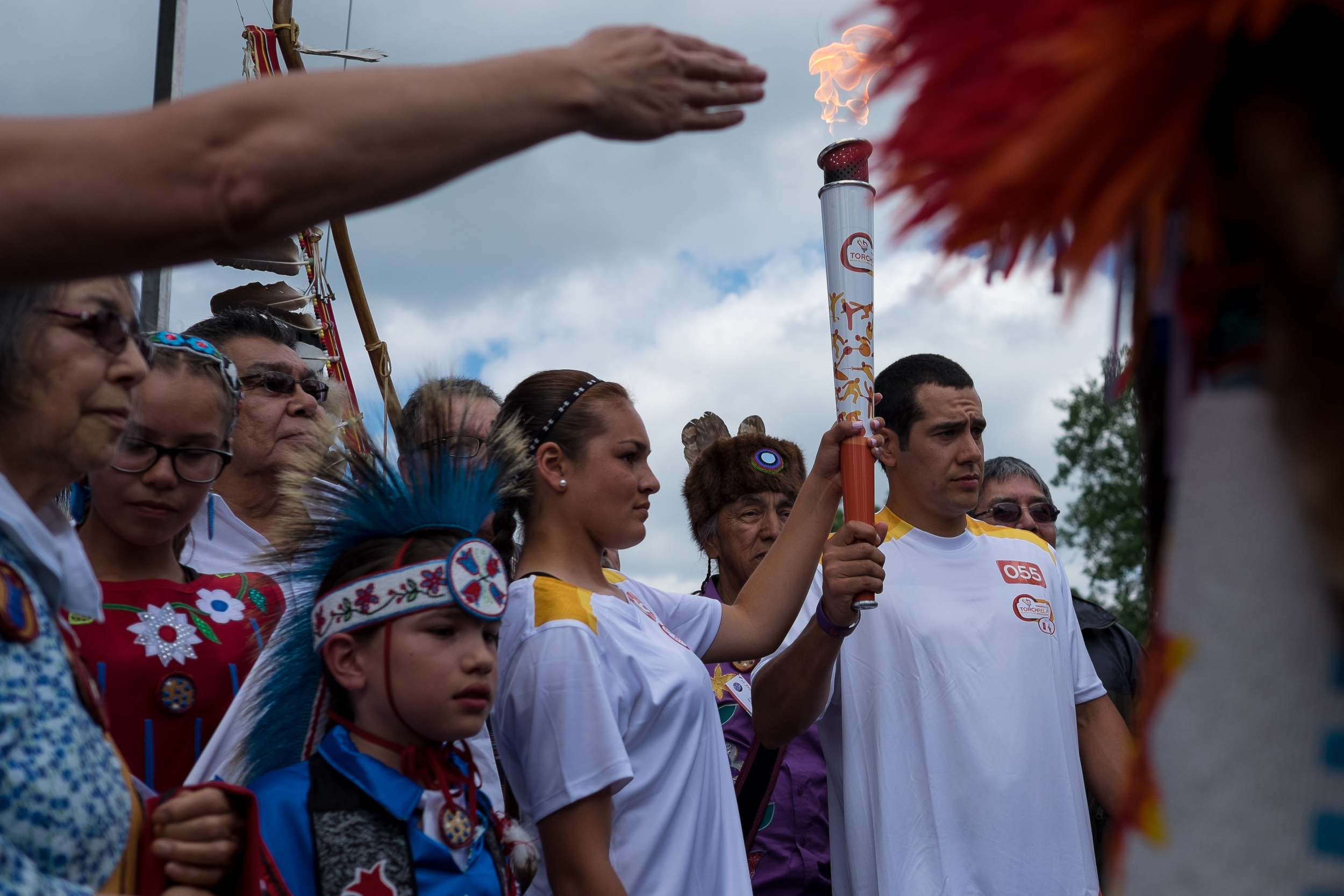 Ryann Laforme (centre) holds the Pan Am torch as during a celebration in New Credit. Charlie Bittern, Bill Chippeway, Charlie Nelson and Bill Merasty stand behind her. 
