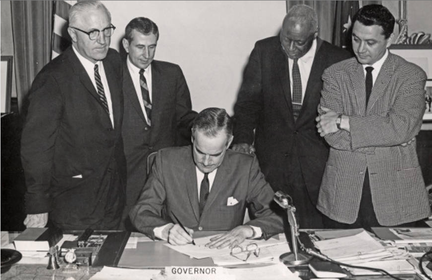  Gov. Matthew Welsh signs the 1963 Indiana Civil Rights Bill (S. 131) witnessed by sponsors (standing L-R) Marshall Kizer, Robert Rock, Robert Brokenburr, and L. Keith Bulen. Photo credit: Indiana Historical Society Digital Image Collections. 