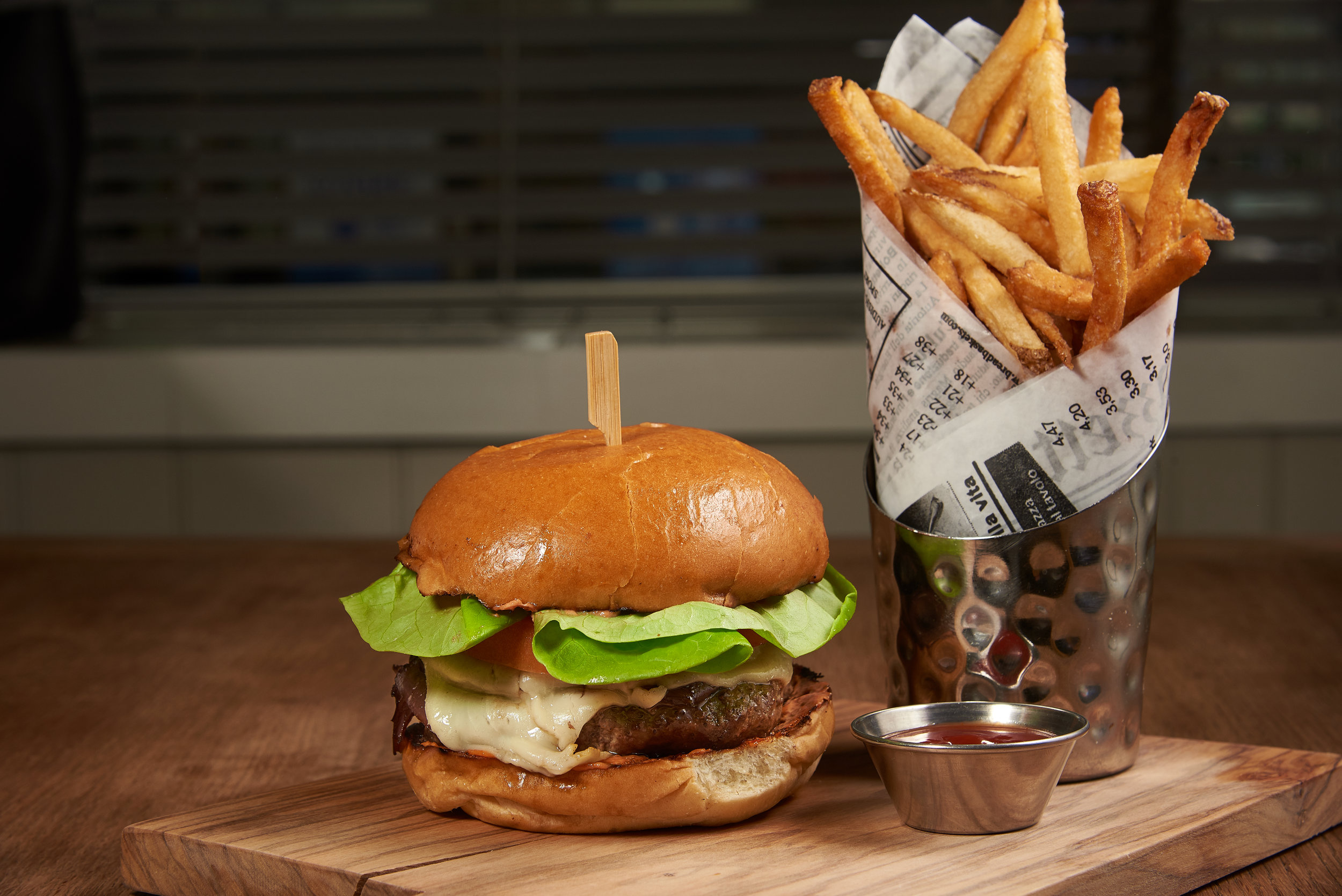 Professional food photo of a juicy cheese burger with french fries. Commercial photography