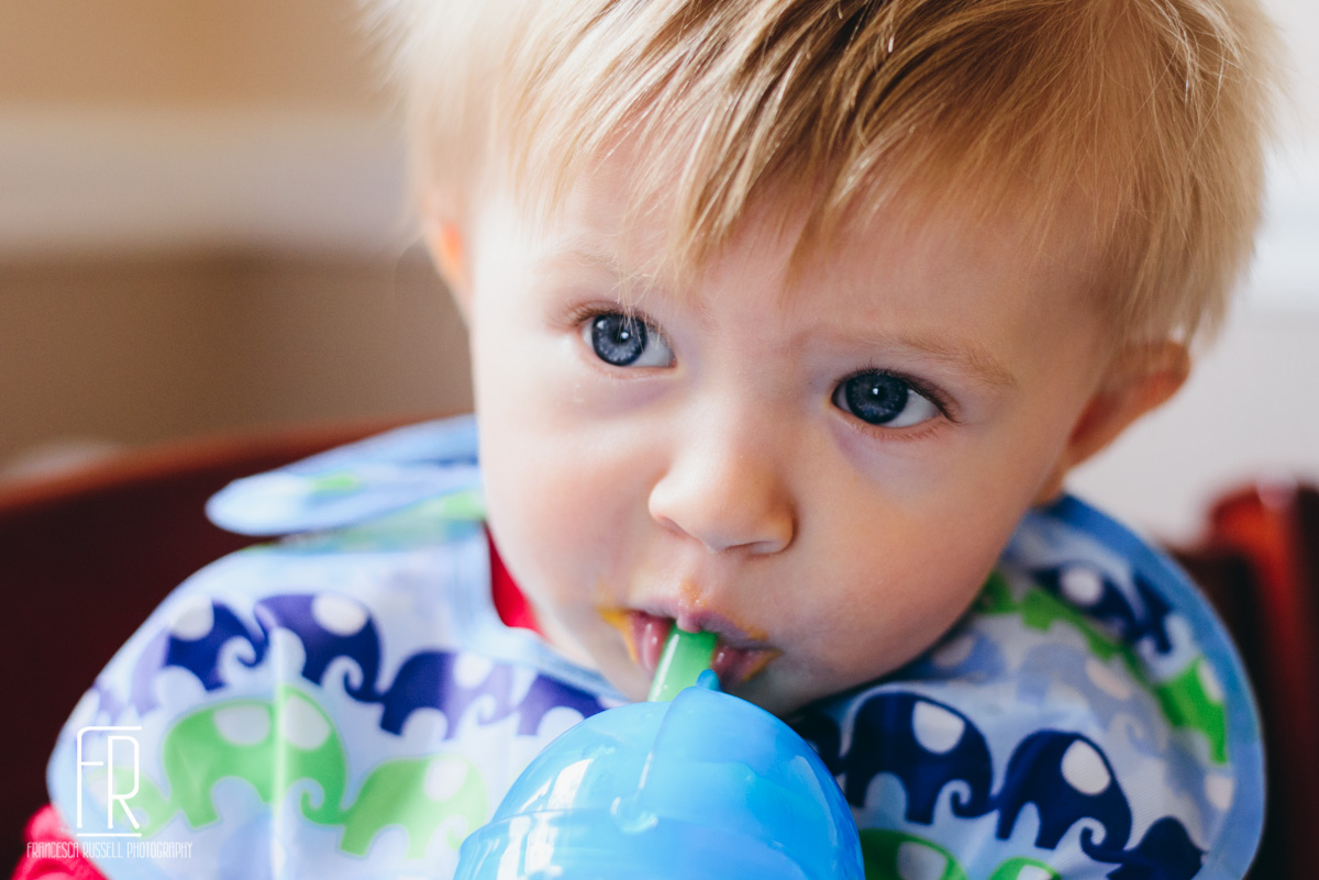 He's not really into solid food, but he has figured out drinking from a straw cup.