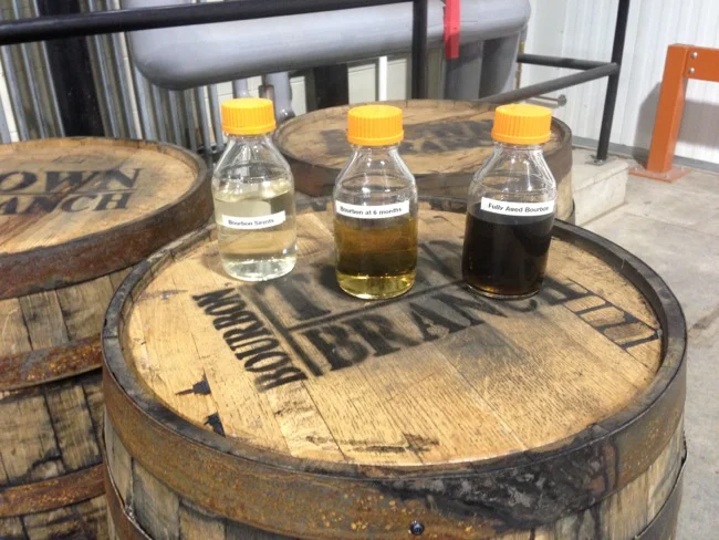 This display shows the effect of barrel aging on bourbon. From left to right you see bourbon fresh off of the still, at six months, and at two years.