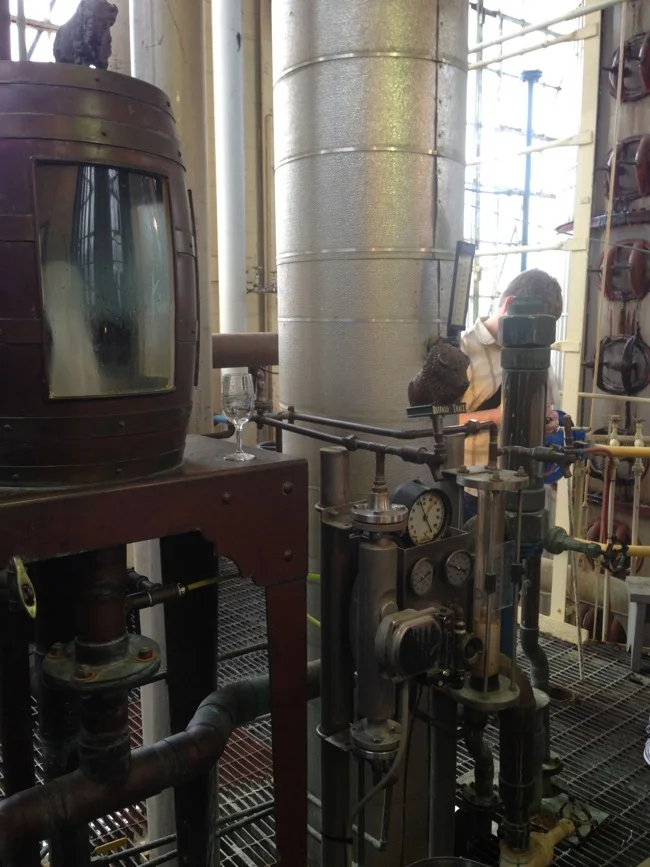 At the top of the still is the tasting box. Here the raw spirits can be sampled and viewed as they come off of the still to determine alcohol content and taste.
