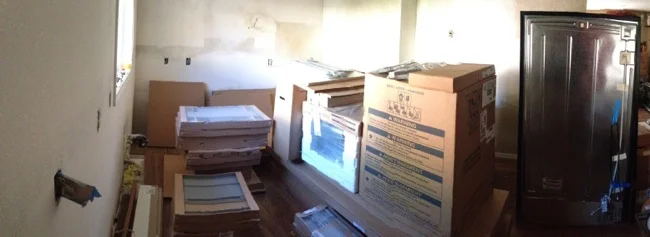 Piles of cabinets and appliances waiting for installation day.