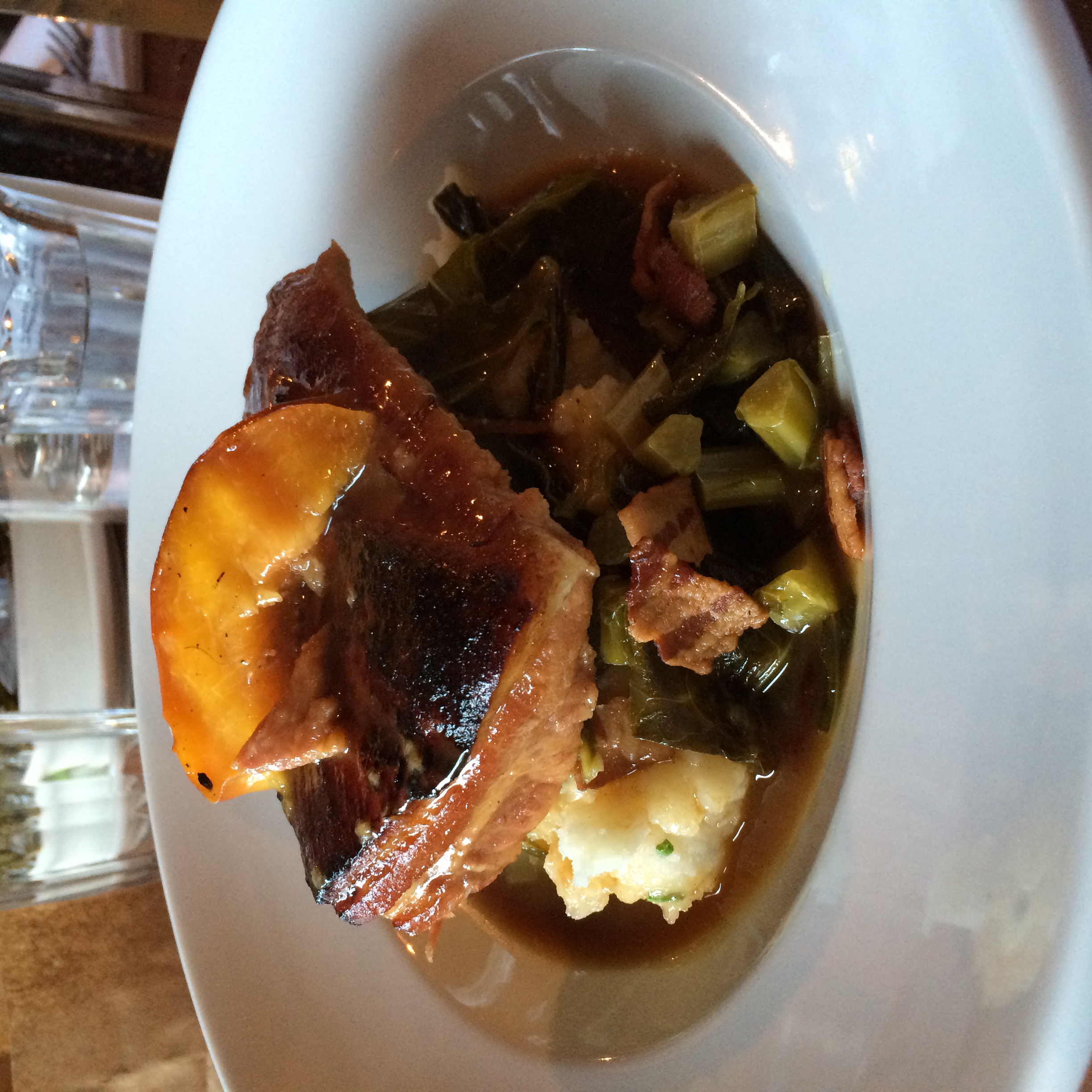 Cider-braised pork belly, bacon-braised collard greens, mash potatoes and a grilled apple
