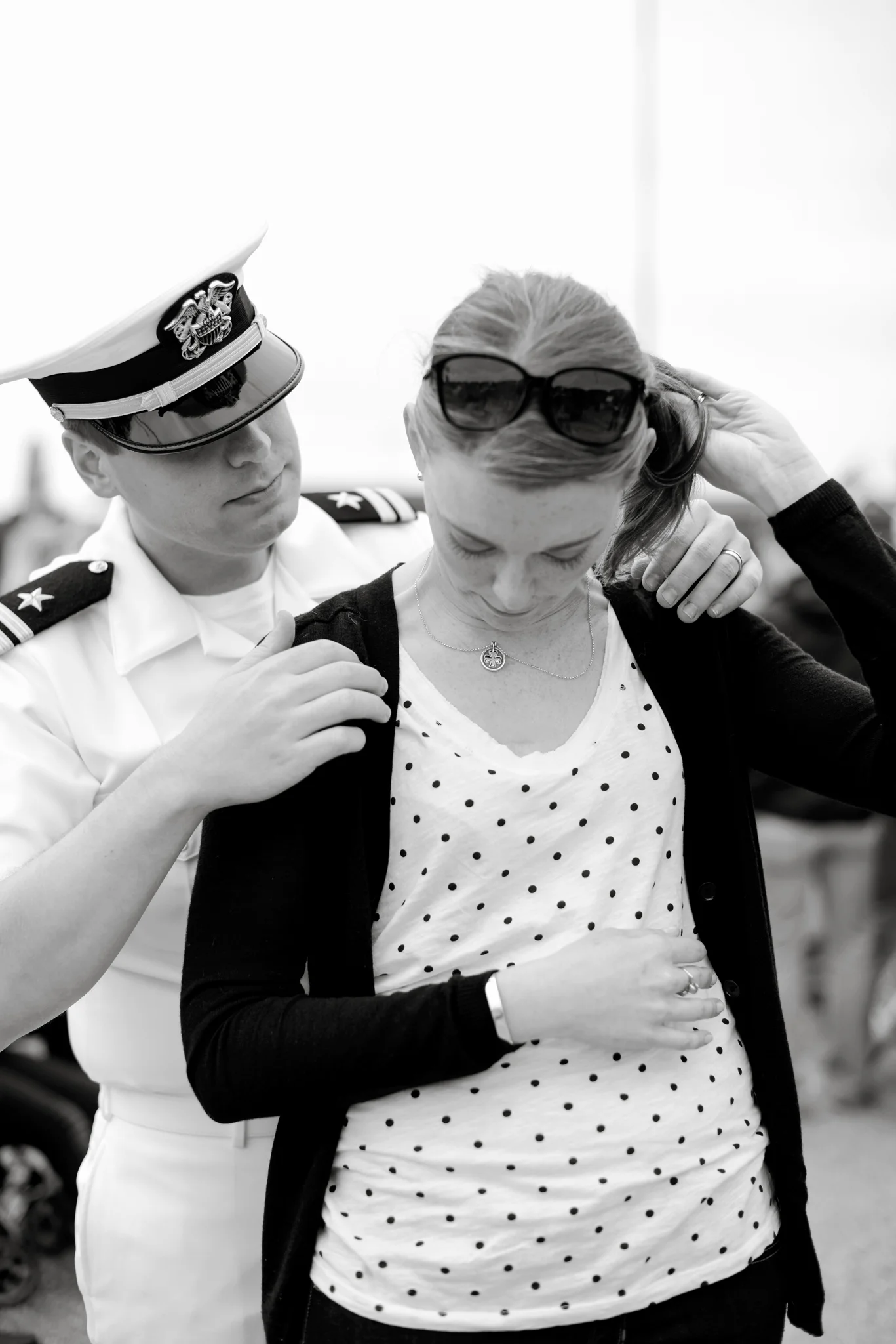 A husband helps his wife put on her shamrock necklace | USS Truman naval military homecoming | Maria Grace Photography