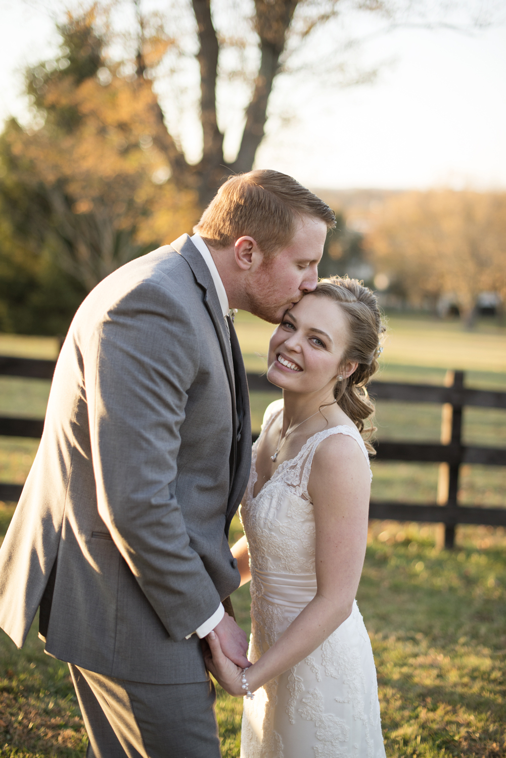Tall groom bends over to kiss his short bride