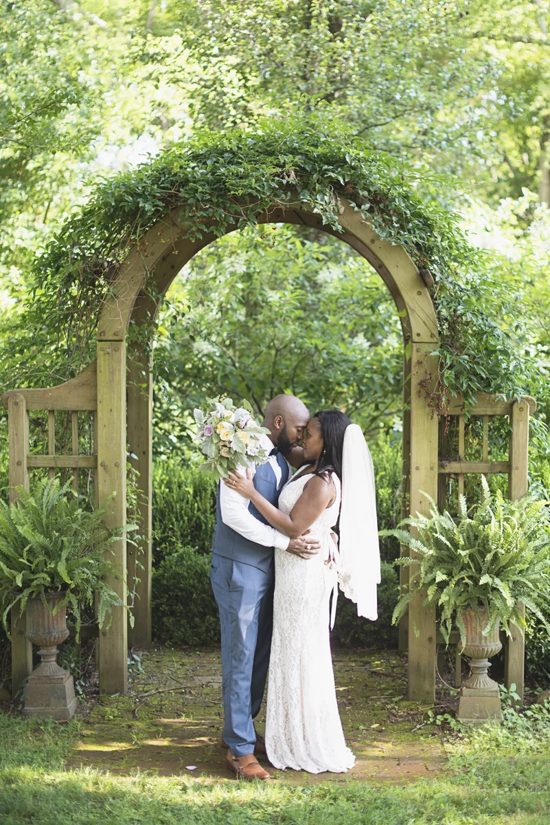 Elegant Lavender Plantation Elopement | Bride + groom portraits under greenery arch