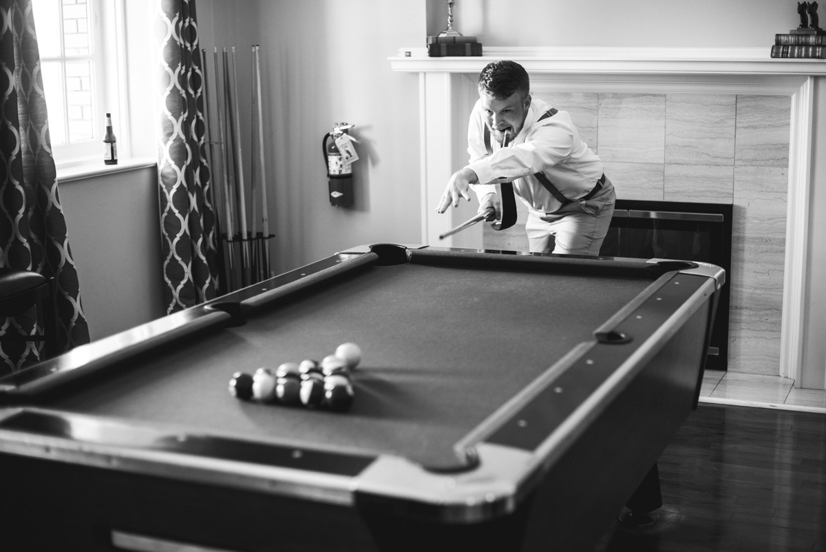 Minimalist White and Green Summer Wedding | Groom playing pool