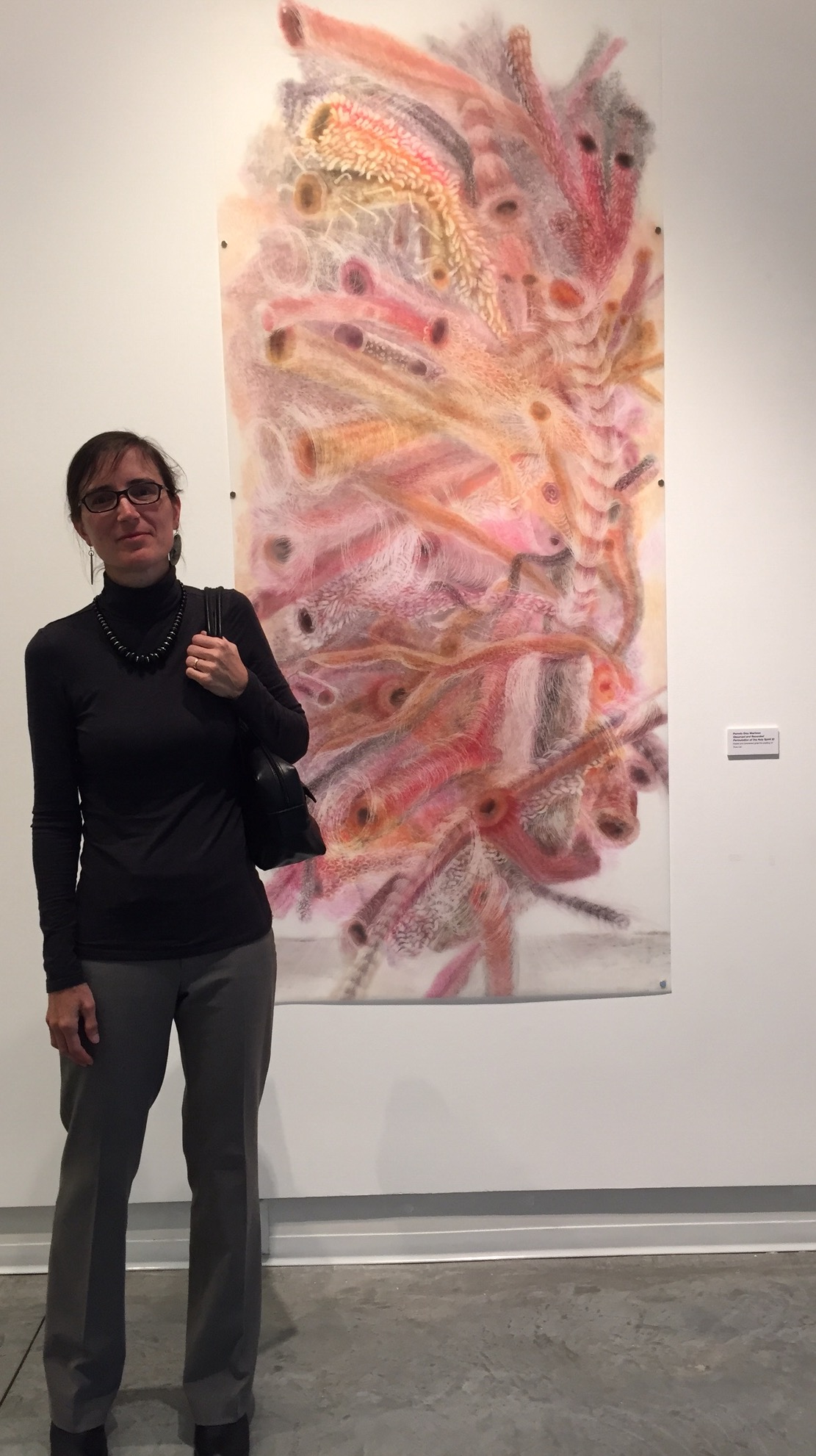 Artist Milada Pisoncikova standing in front of my pastel erasing. Title: Observed and Recorded Permutation of The Holy Spirit XI (40 inches x 79.5 inches-pastel and powdered graphite erasing on dura-lar)