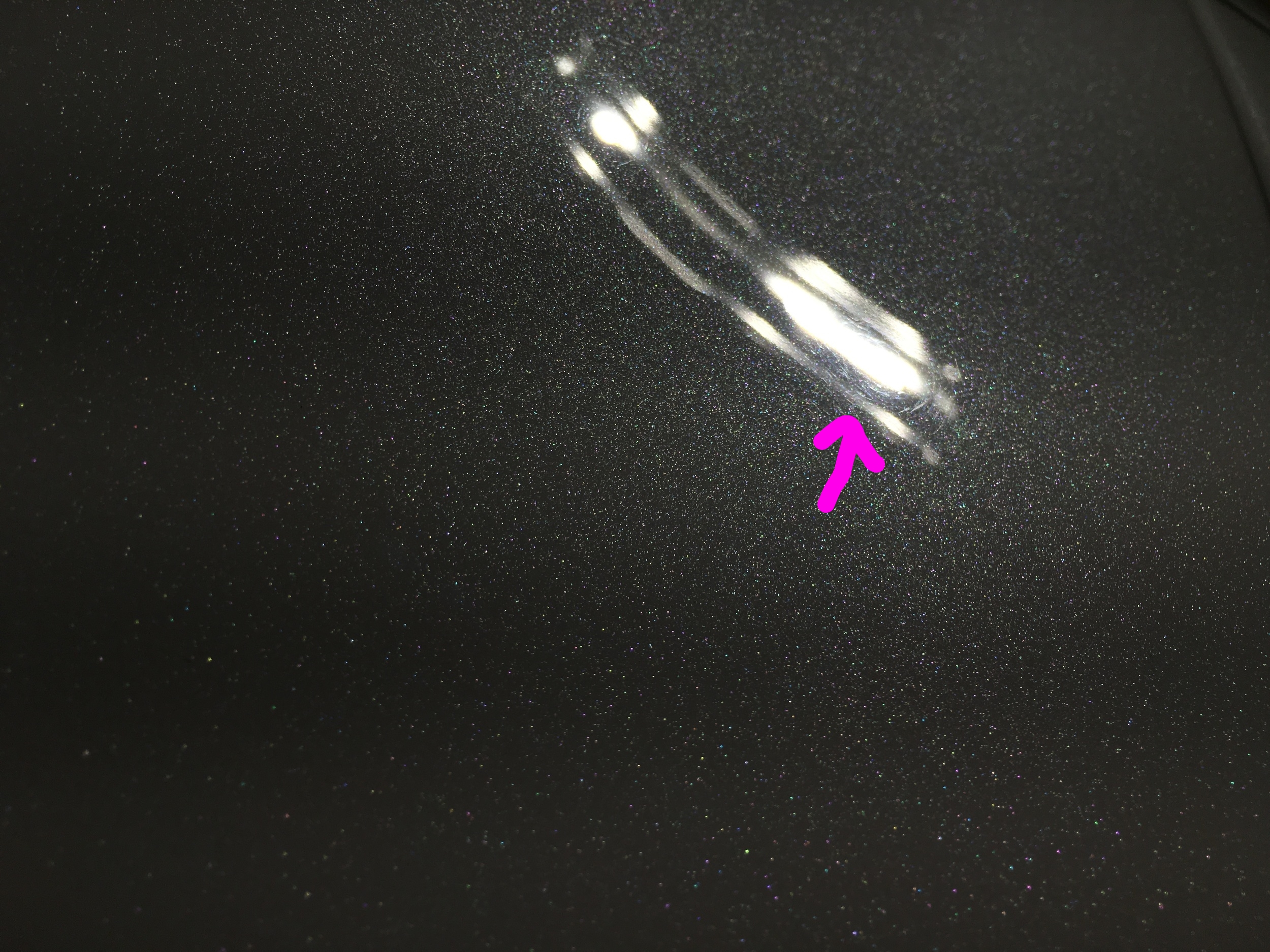 Minor surface defects captured on the hood under LED lighting