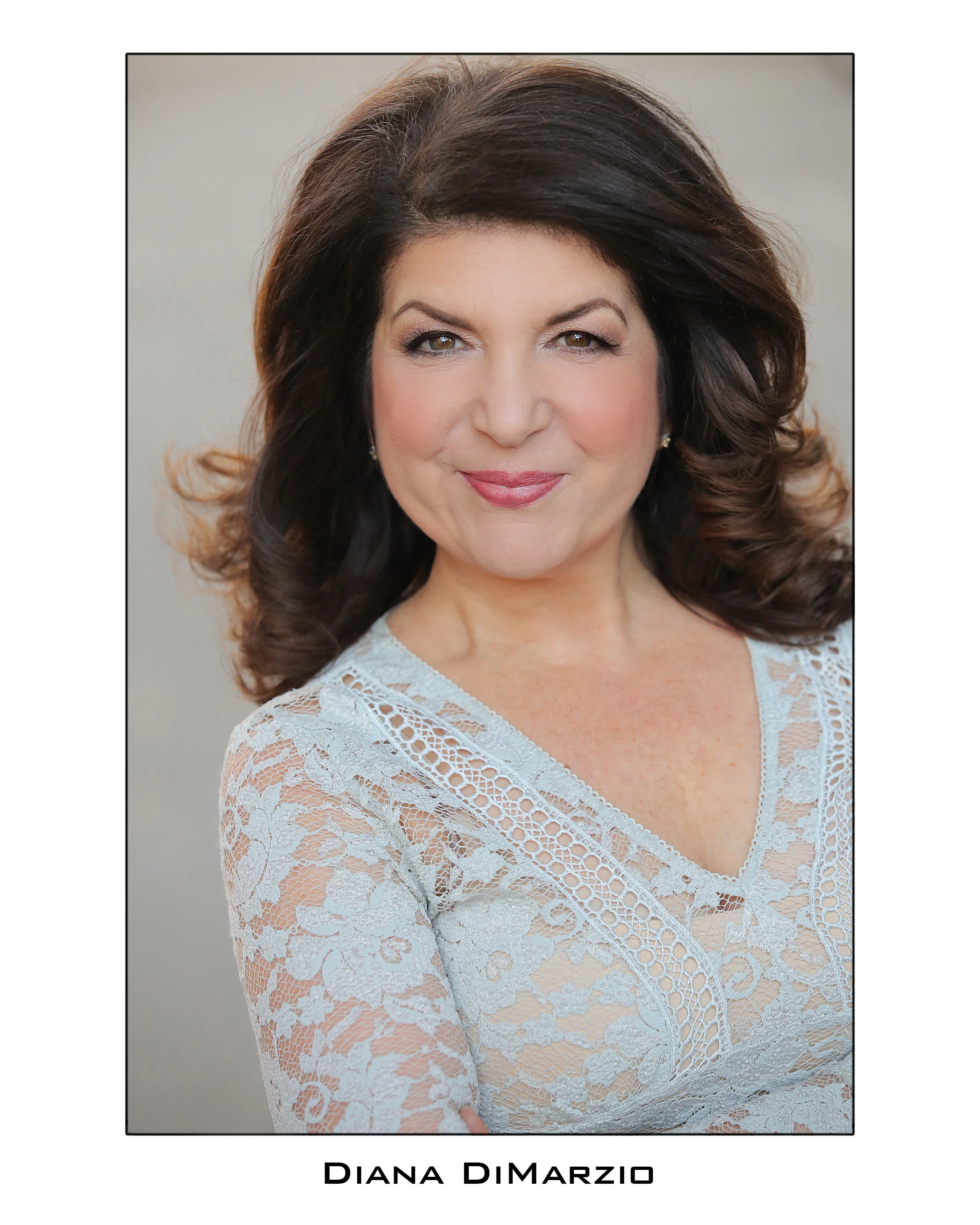 Professional headshot of a smiling woman with dark hair.