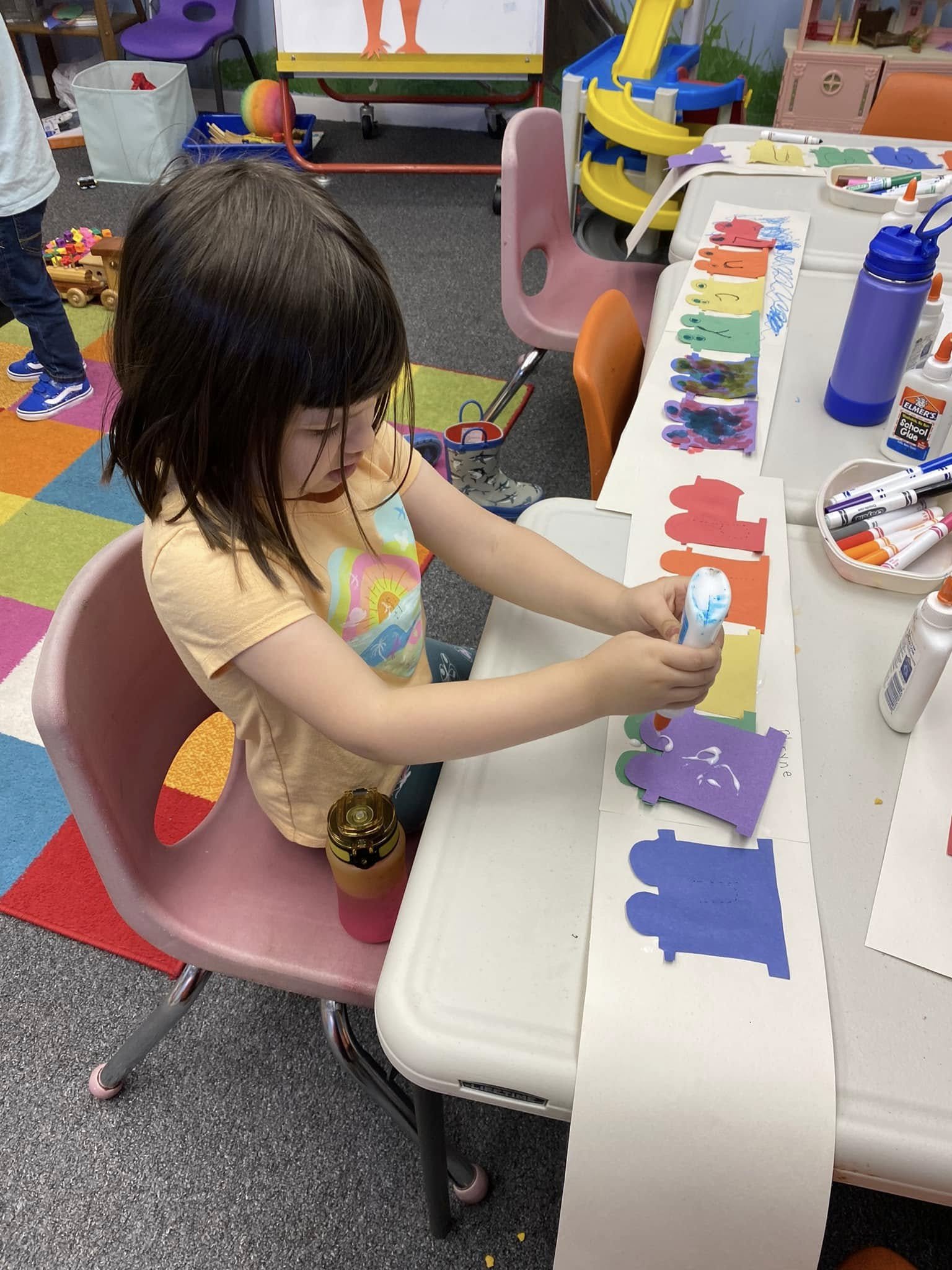 A preschooler uses glue while working on an art project during class in Boyertown PA.