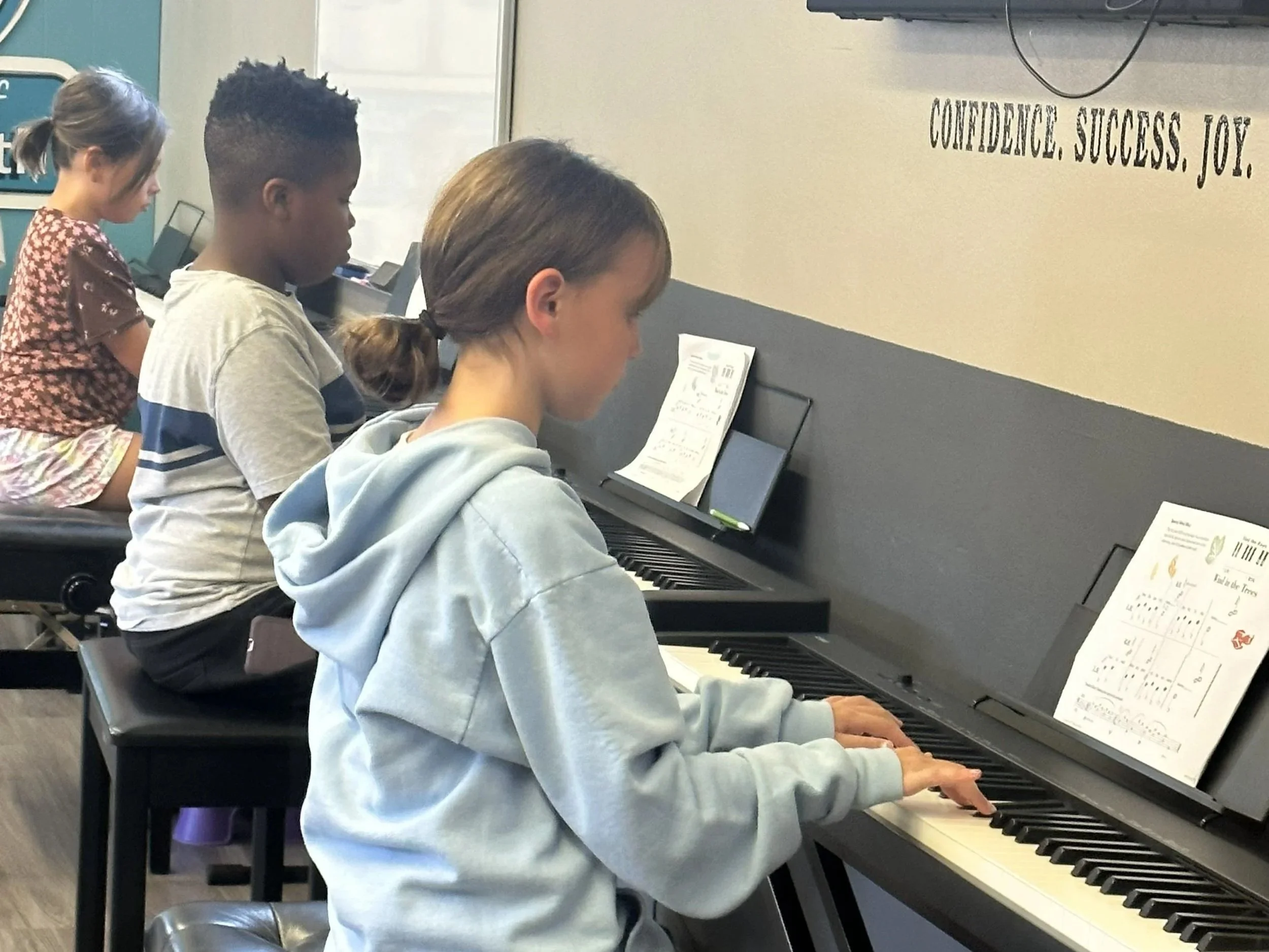 Several piano students work independently at keyboards during their Encore piano class at the Music Studio of Patricia Keith in Boyertown PA.