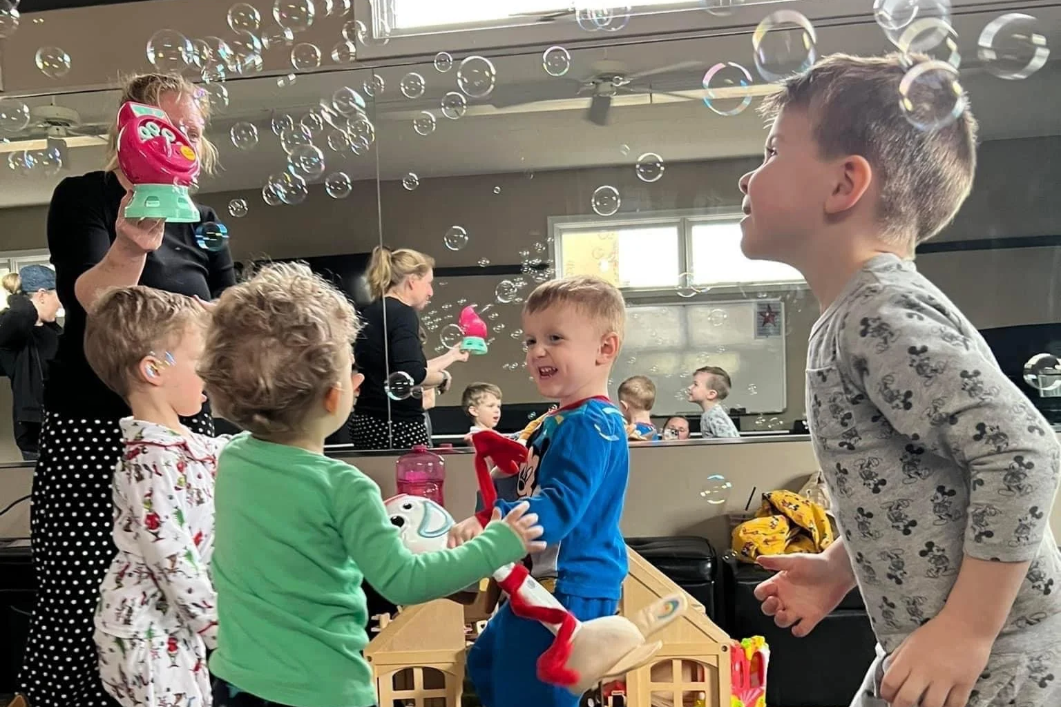 A class of young children enjoy bubbles during playtime.