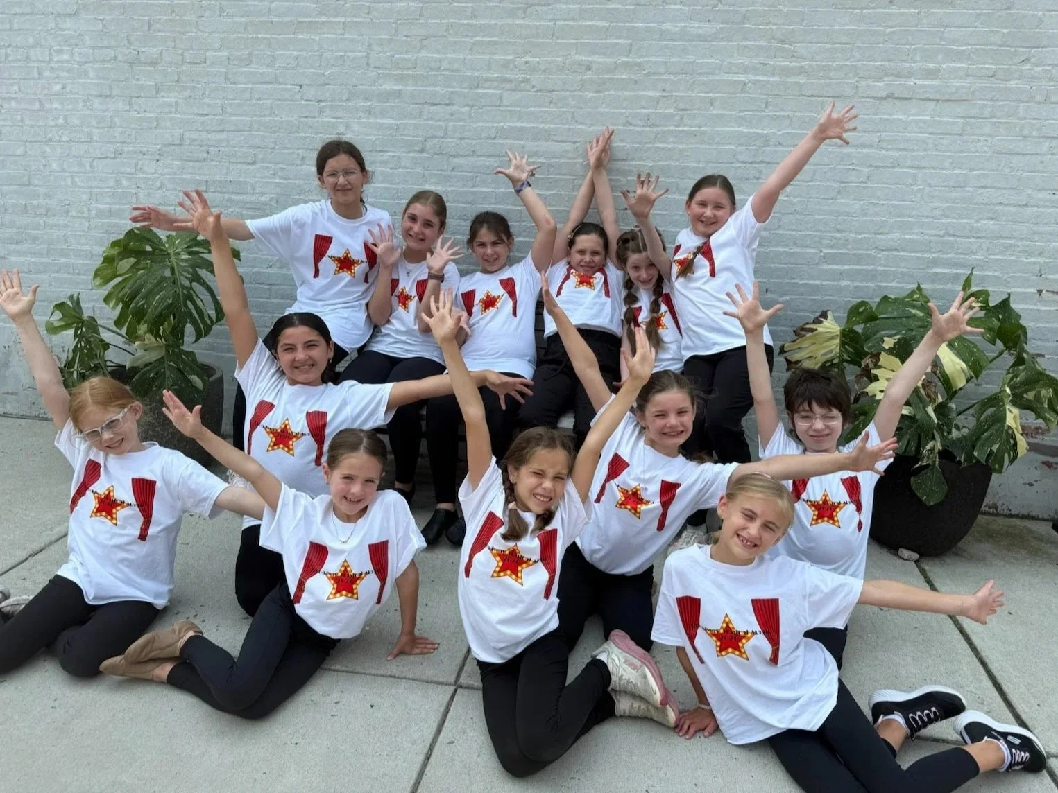 A group of students is outside showing off their finale pose for a performance.