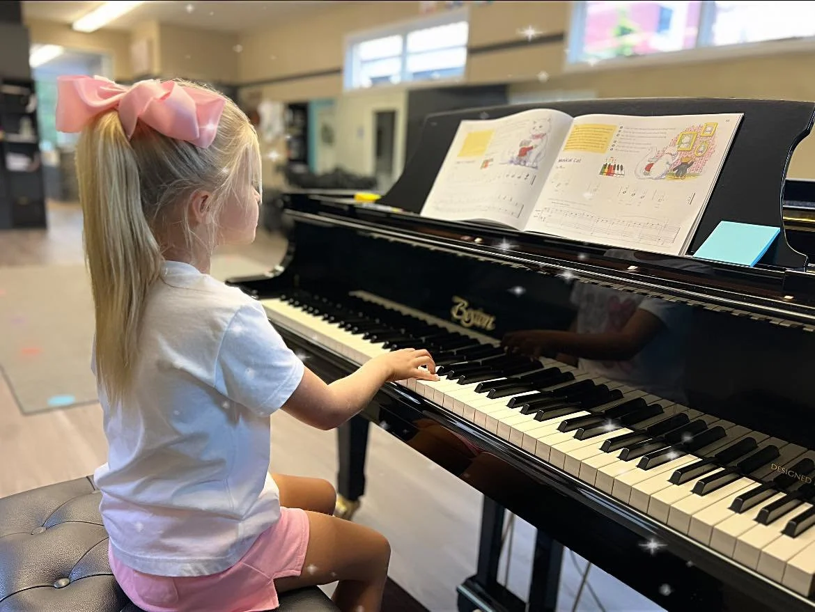 A young girl sits at the grand piano at the Music Studio of Patricia Keith in Boyertown during her Little Mozarts piano class.