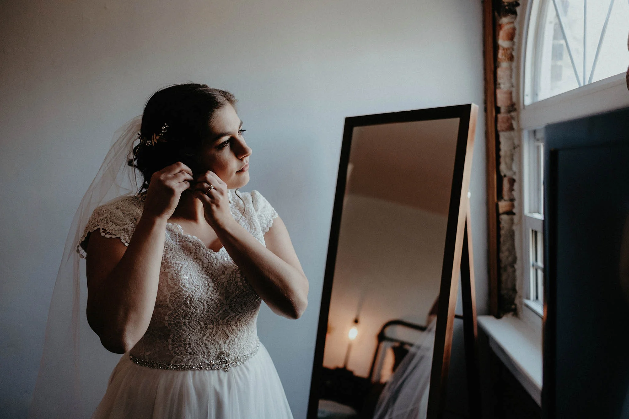cincinnati warehouse wedding photographer bride putting on earrings
