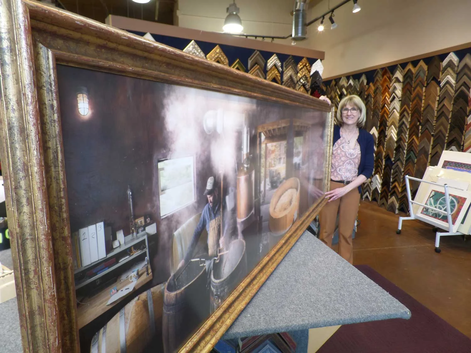 Myrna Dow of High Desert Frameworks braces the large 33" x 102" framed photograph.