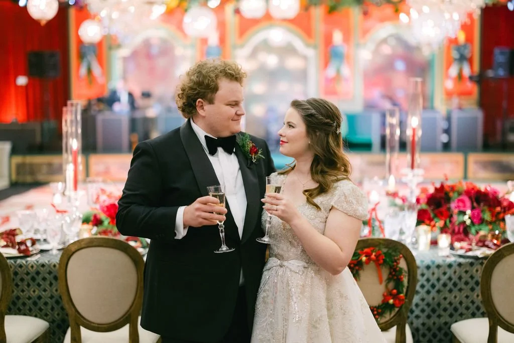Bride and groom smiling at each other and toasting with champagne glasses at their Christmas reception at The Four Seasons Chicago