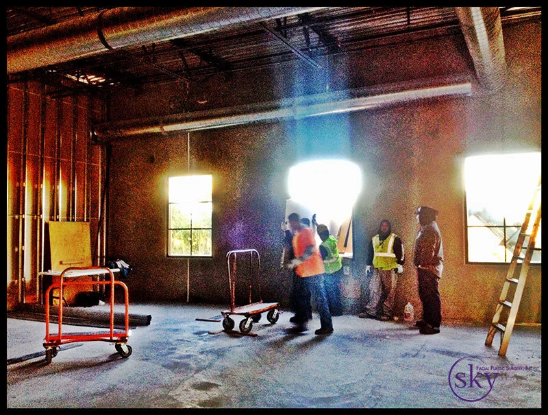 PHOTO: Construction crew unloads material from the crane through the window.