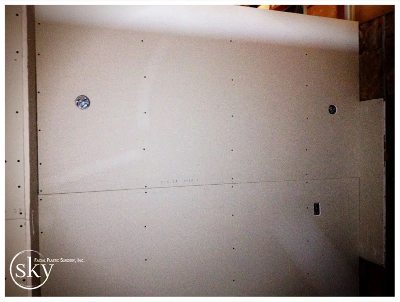 PHOTO: The drywall in the consultation room, with holes where the sconces will be placed.