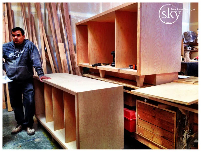 PHOTO: Crafstman standing next to credenza he is building.