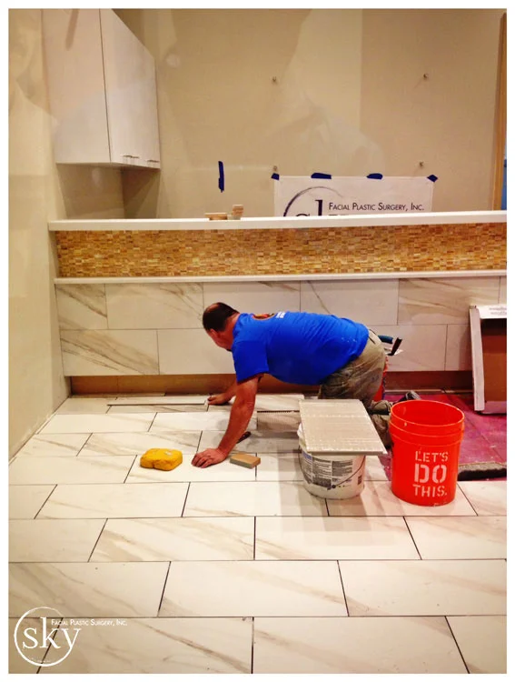PHOTO: Man installing floor in lobby.