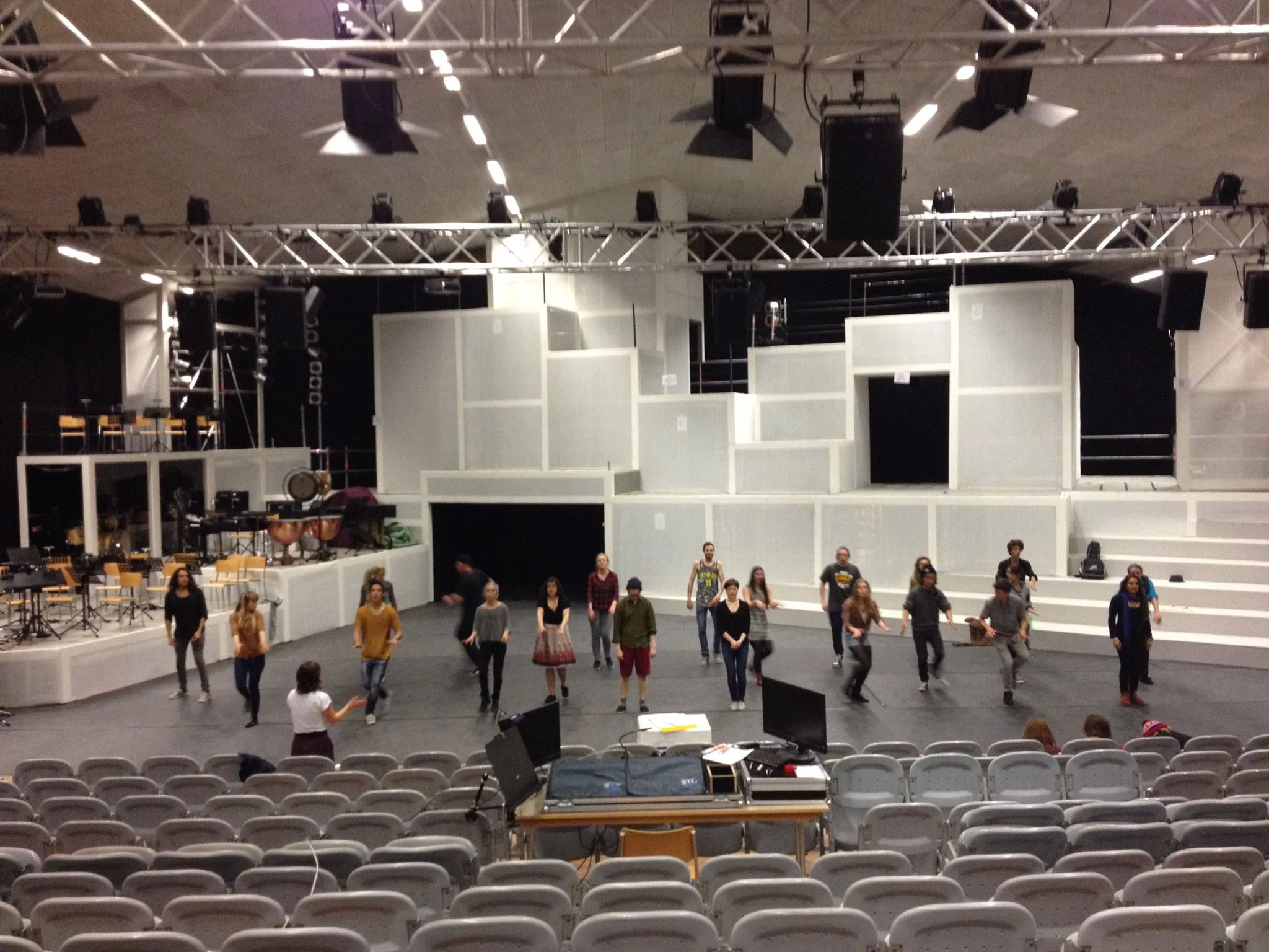 a picture taken during rehearsal - the stage was huuuge!! We built it in a really big gym we rented. The white netting could be used to project images onto it, but it could also be lit from the back to make "shadow pictures" and when light sources right behind the net where turned on, you could see actors standing right behind it, kind of like turning on a TV screen, it was really neat!