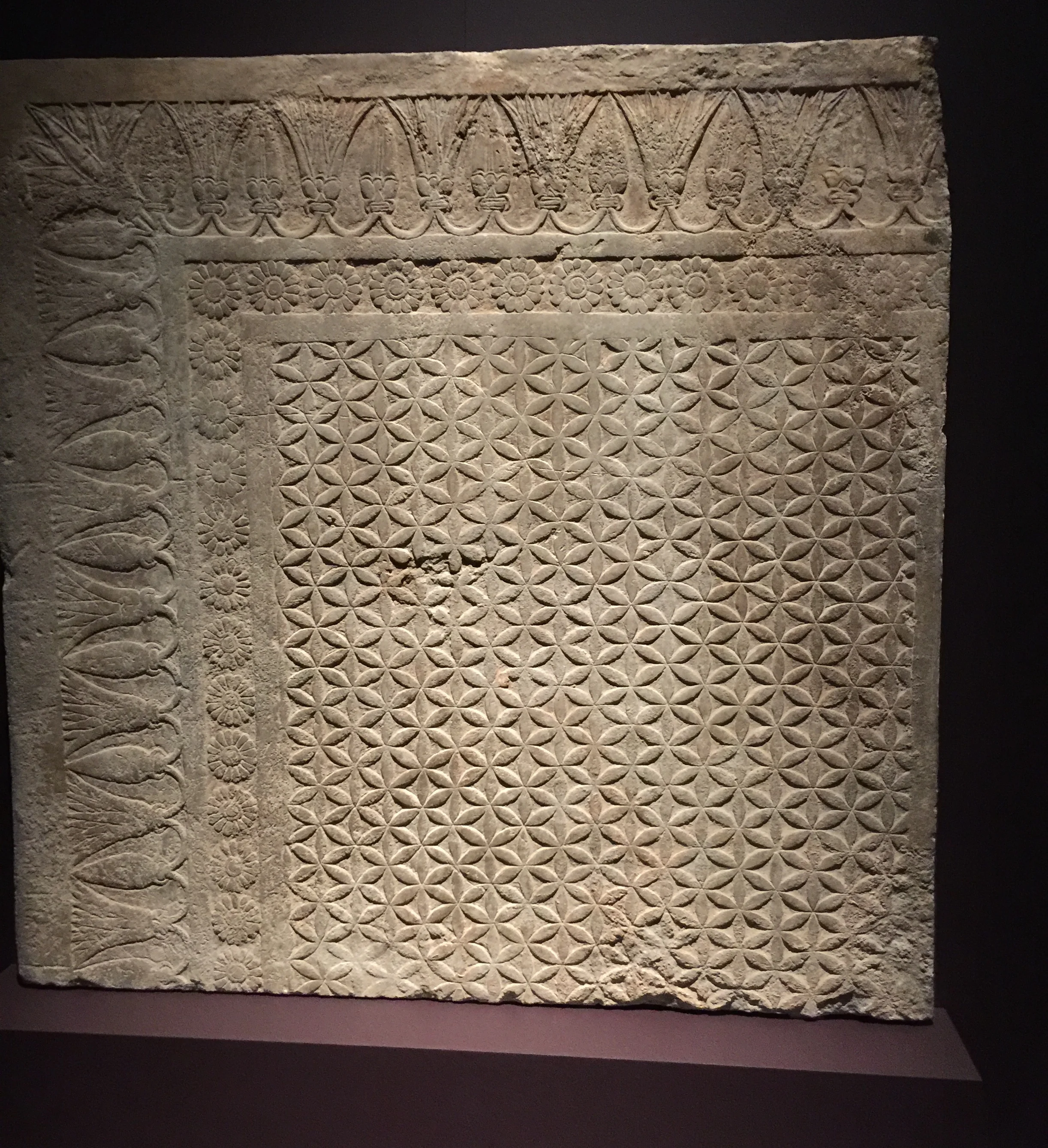 Assyrian carpet motifs carved into a floor tile - fancy.