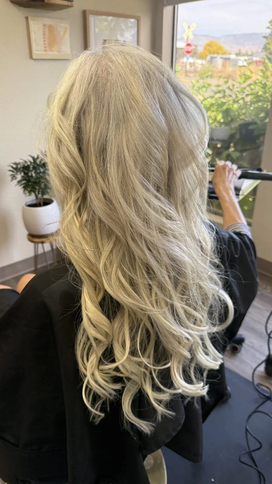 Long silver blonde hair extensions with soft curls at a Boise hair salon