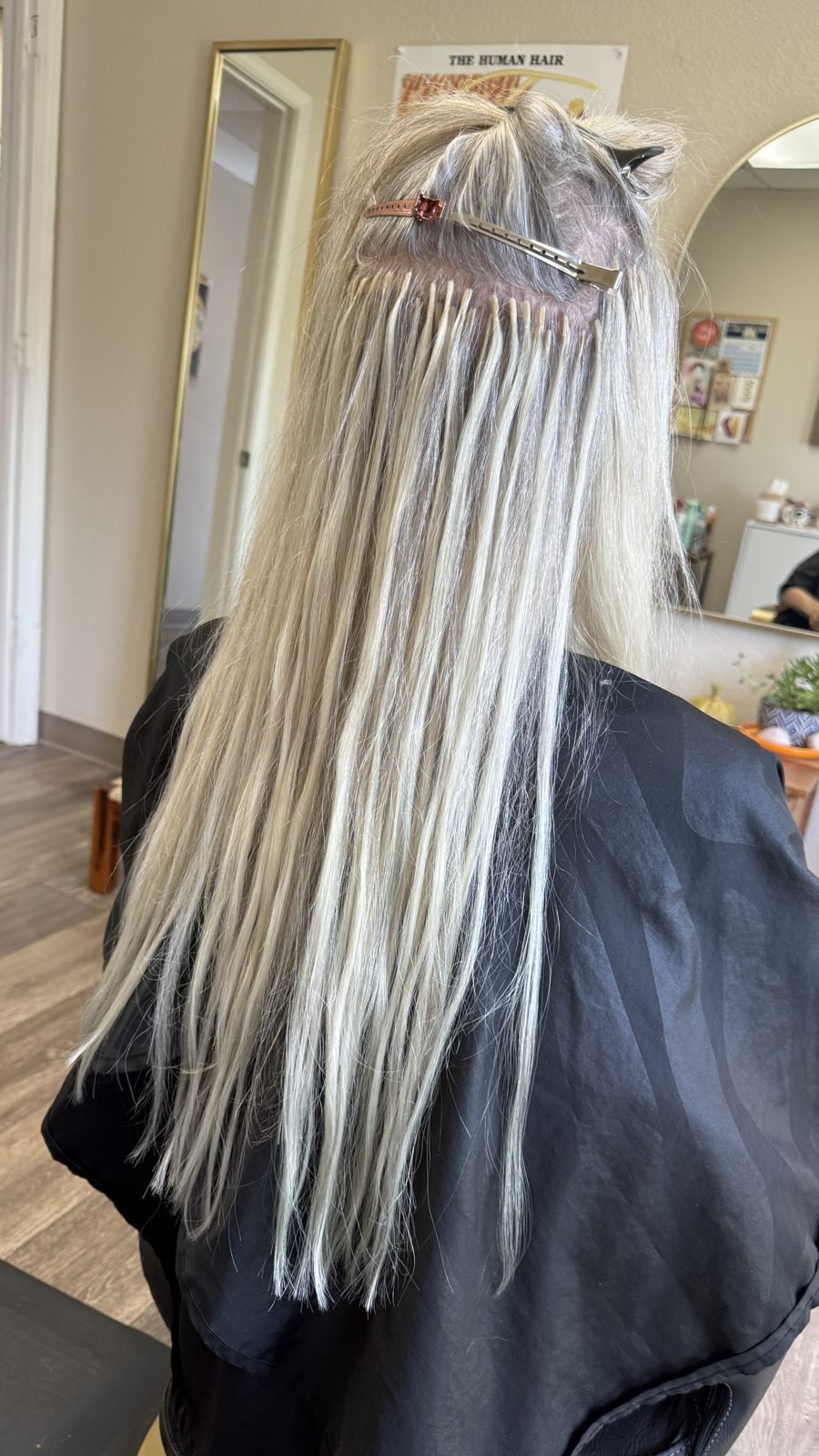Rows of I-tip hair extensions installed on silver blonde hair before styling at Fusion Studio in Boise