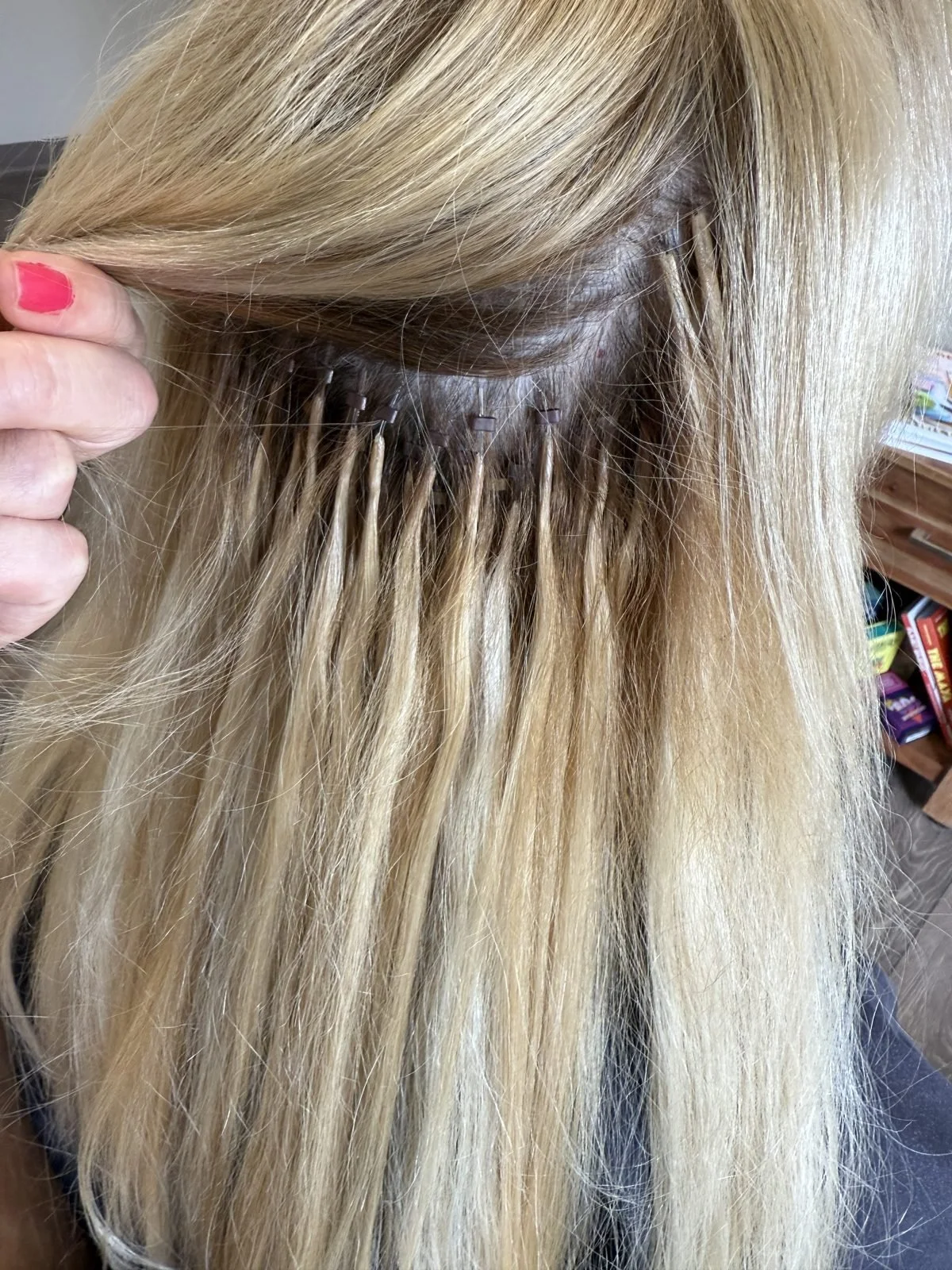 Close-up of microbead hair extensions installed in rows on blonde hair in Boise