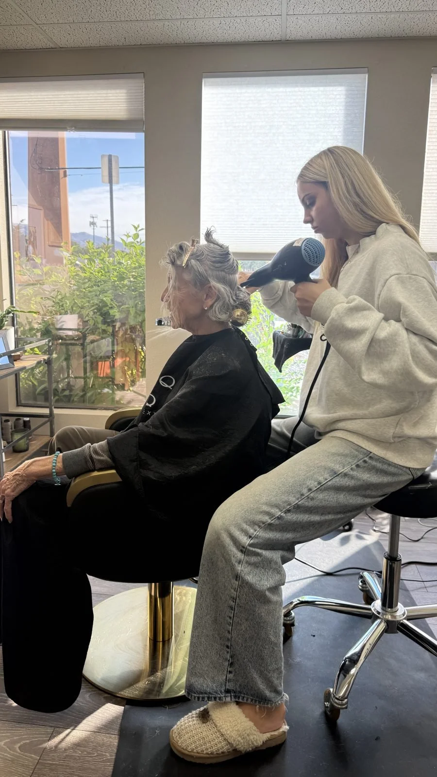 Julia Bridges blow-drying a client's silver hair at Fusion Studio in Boise