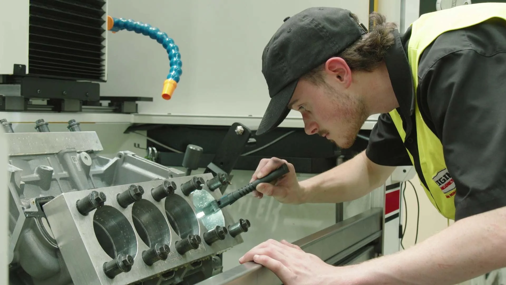 A technician working on a mechanical engine part in a professional workshop.