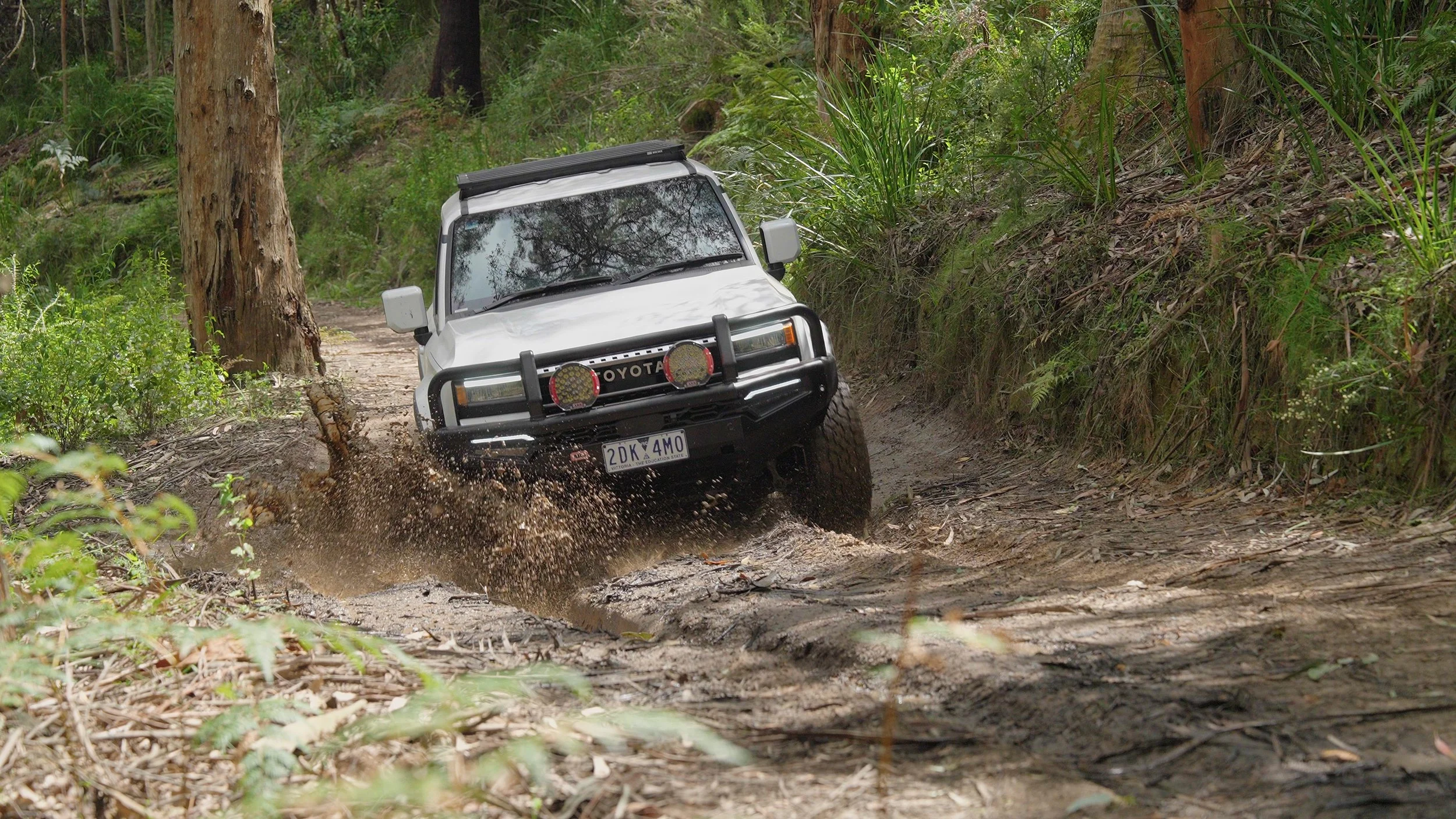 Toyota Prado with ARB Edition Accessory Kit driving through puddle of mud