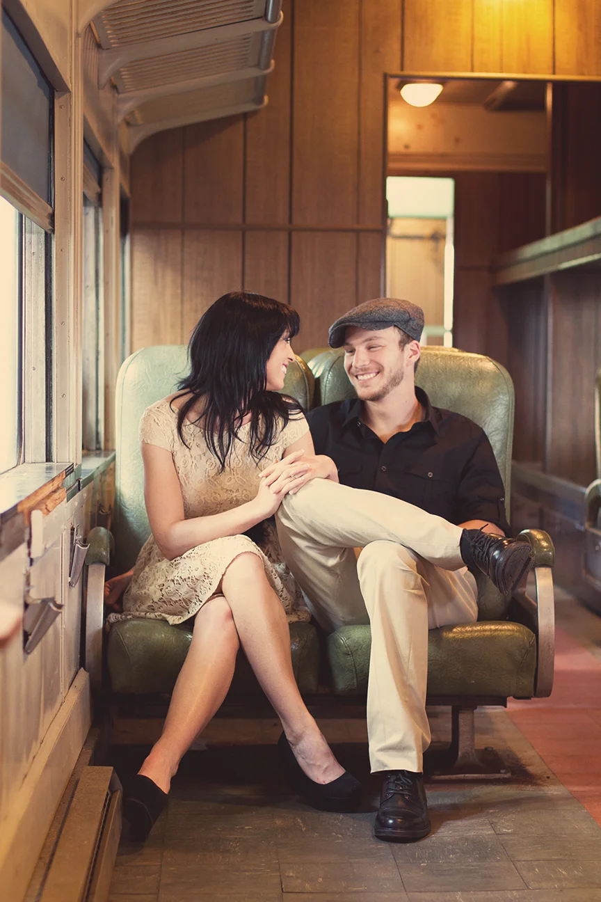 Hilary & Sam_Smiling at each other on train seated_web.jpg