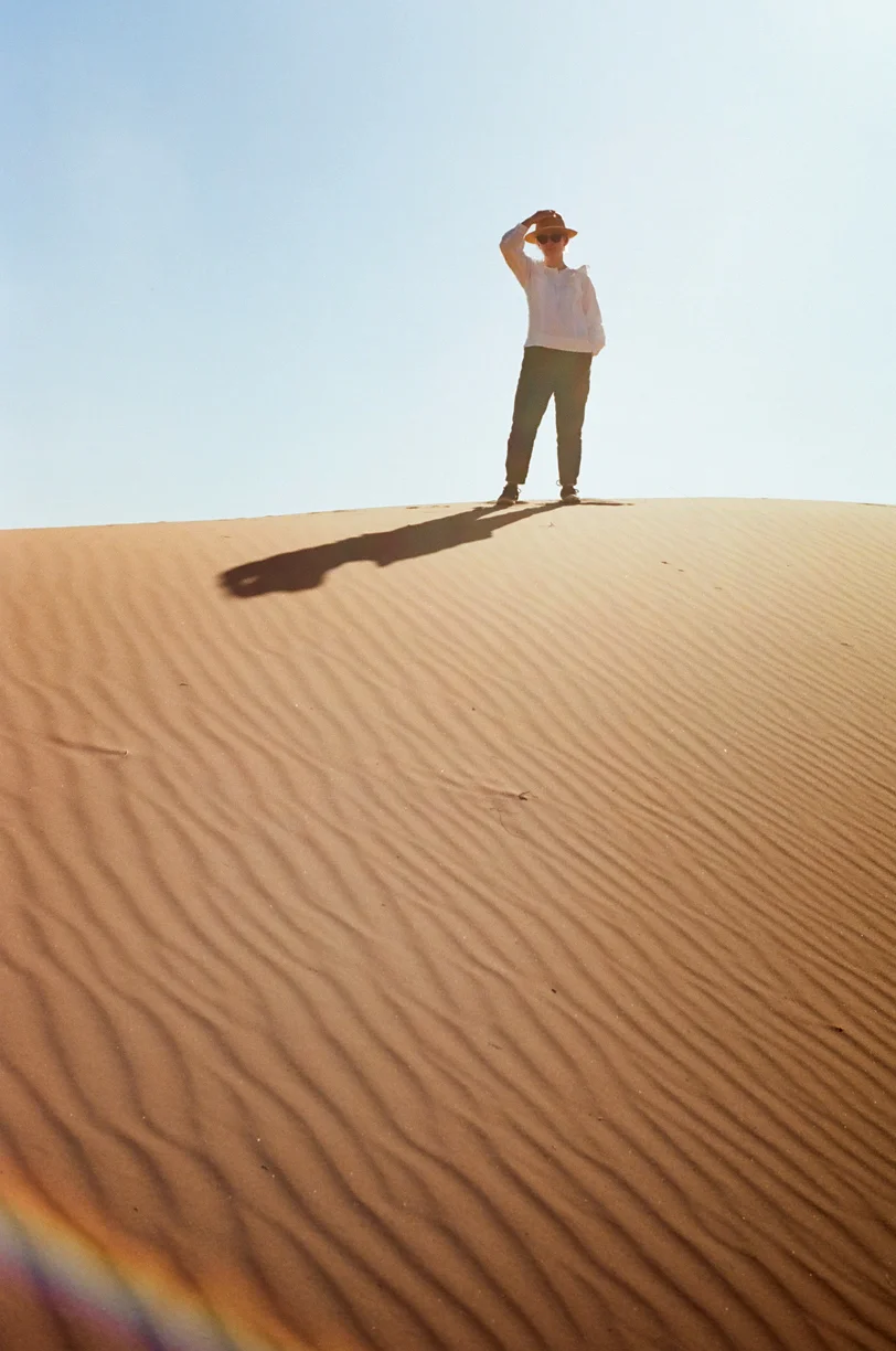 Allison with Hand on Hat_Vertical_Rainbow on Sand_web.jpg