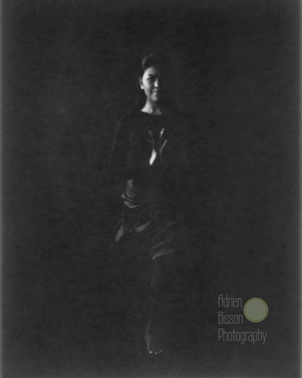 This shot was done using a 4x5 inch paper negative. Photographic paper is 'orthochromatic', unlike traditional film, so certain colors do not register as one might expect. Her yellow garment is the same one as in the color image above, but reads almost black.