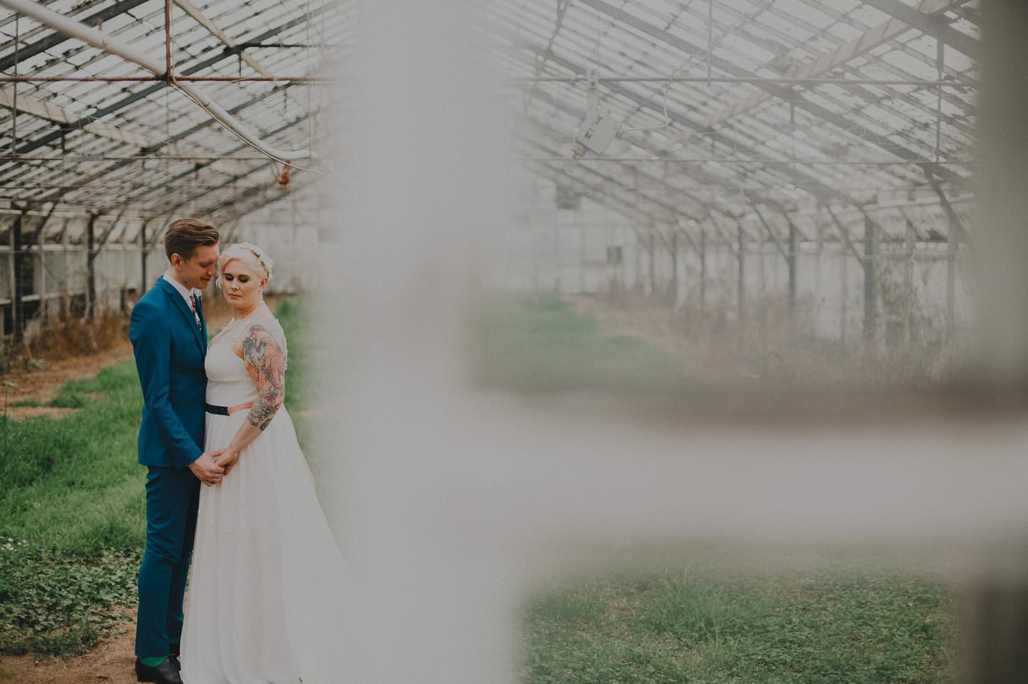 Artistic wedding photography of couple in a glass house