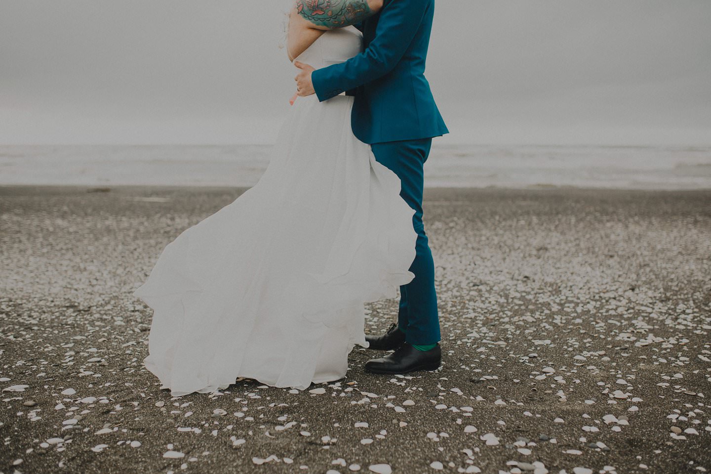 Sally Eagle Marilyn Gown; Bride and groom embrace on the beach