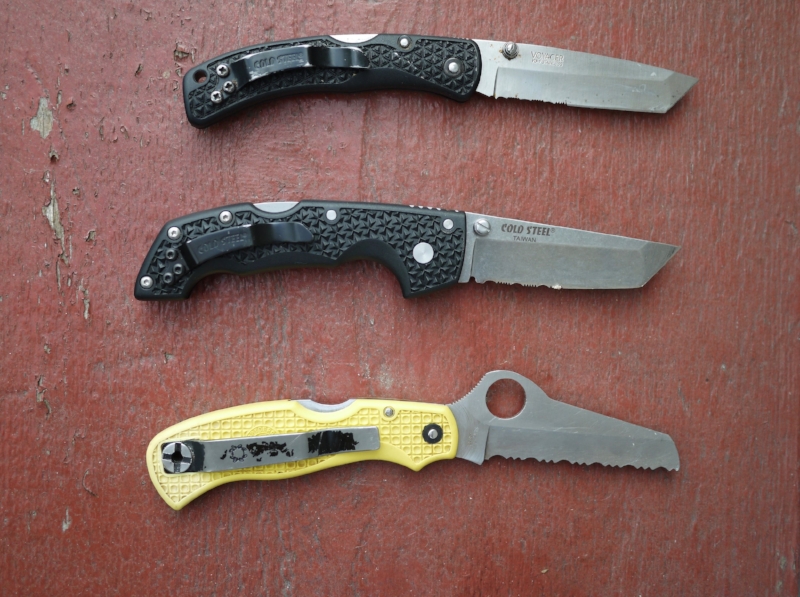 My beloved and well-worn field knives - older model Cold Steel medium Voyager on top, newer model in the middle, and Spyderco Saver Salt on the bottom. 