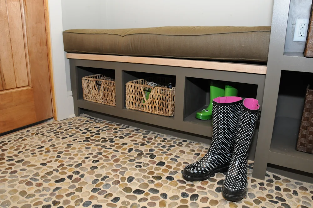 Detail of Pantry/Mudroom at Southern Living Idea Home Davidson Gap. Painted poplar cabinet, Hard maple seat top, and river stone floor.