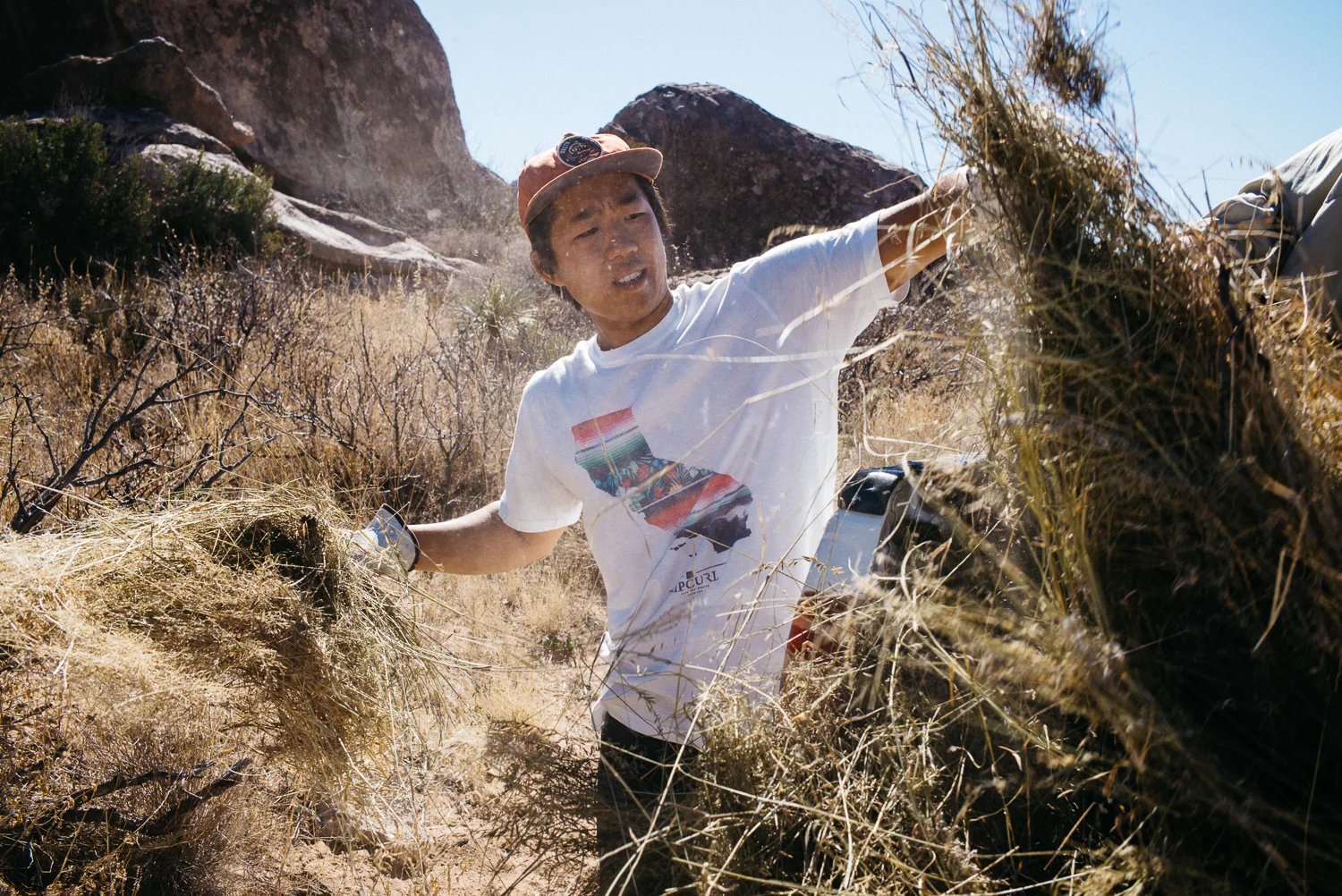 Ben Lim picking up hay as a volunteer with the Access Fund and placing it down after the gravel removal to help mitigate erosion. Michael Lim Photography 2015 ©