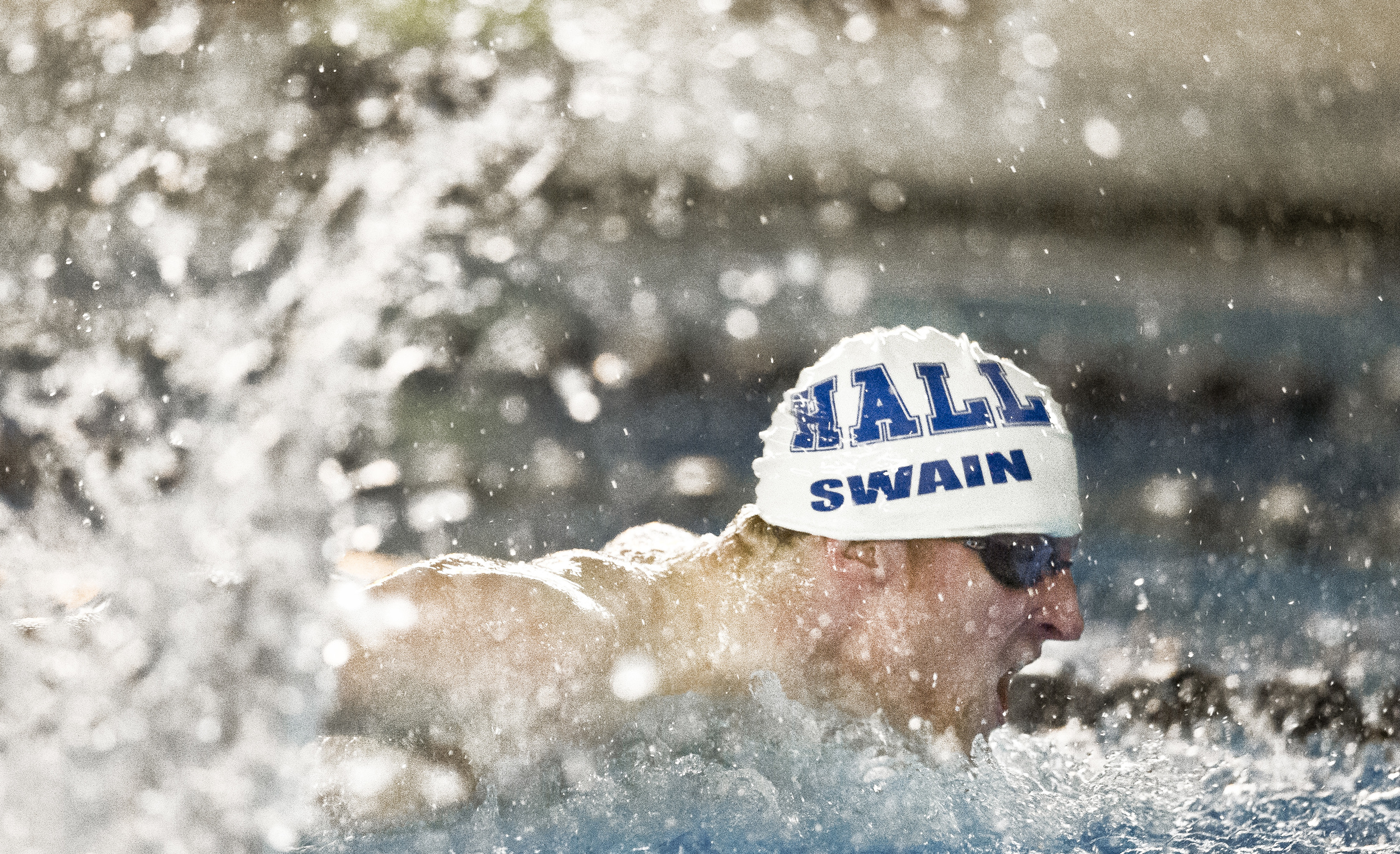 Hall High School's Ethan Swain takes one last stroke during the 100-yard Butterfly against Wethersfield at the Cornerstone Aquatic Center in West Hartford, Connecticut.