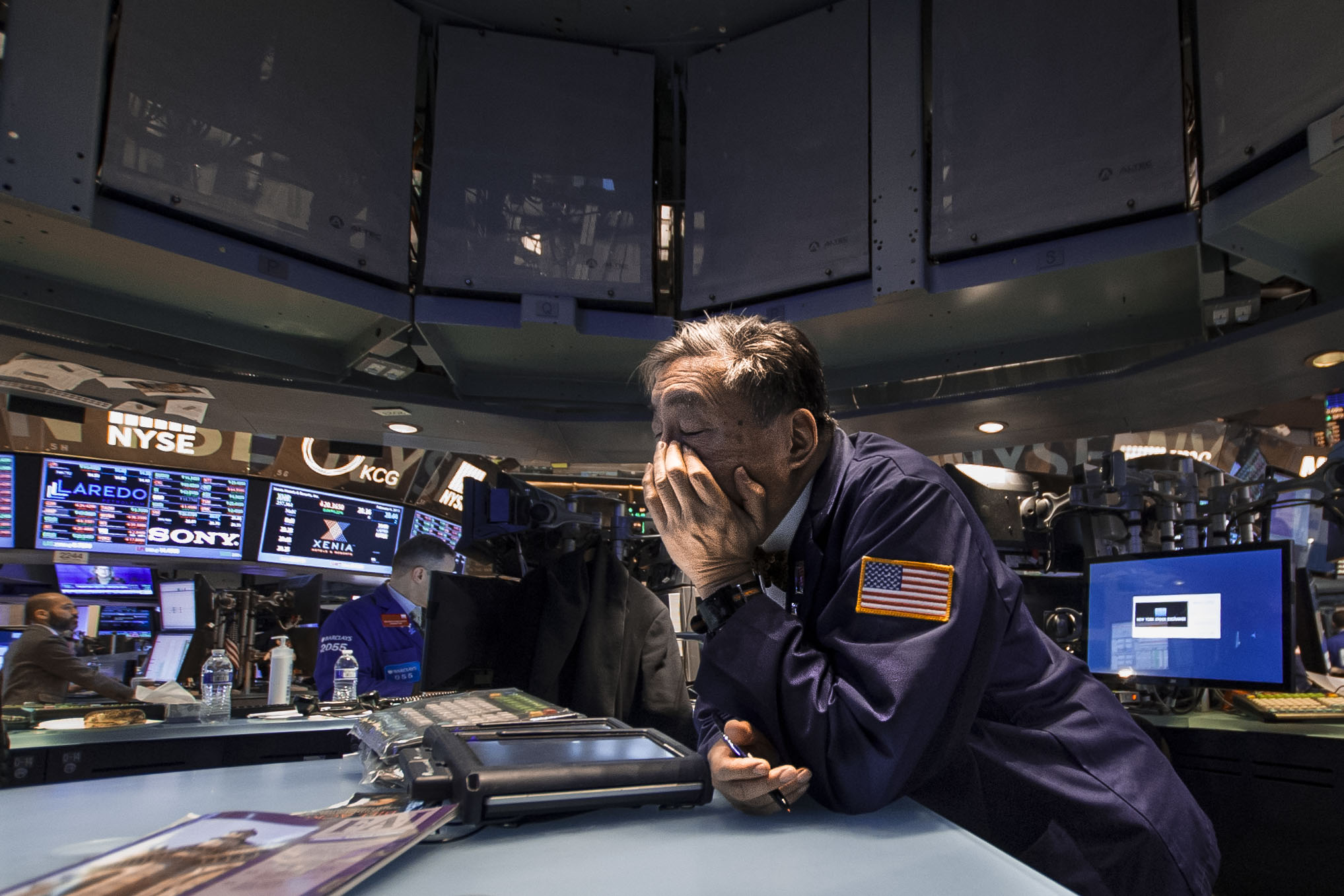  A floor trader rubs his eyes after a long day. 
